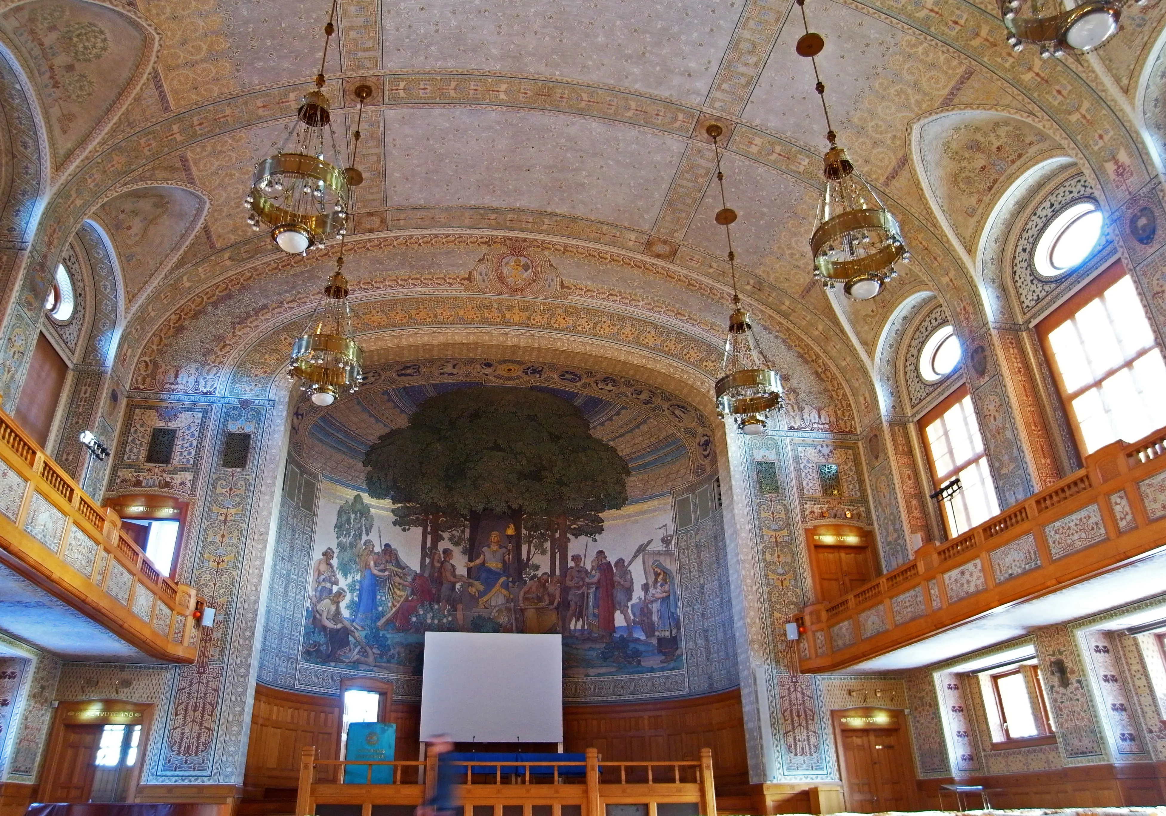 Aulan i Göteborgs universitetshus bär drag av ortodox kyrko-interiör. Väggarna och det välvda taket är täcka av dekormålning i jugend-stil.