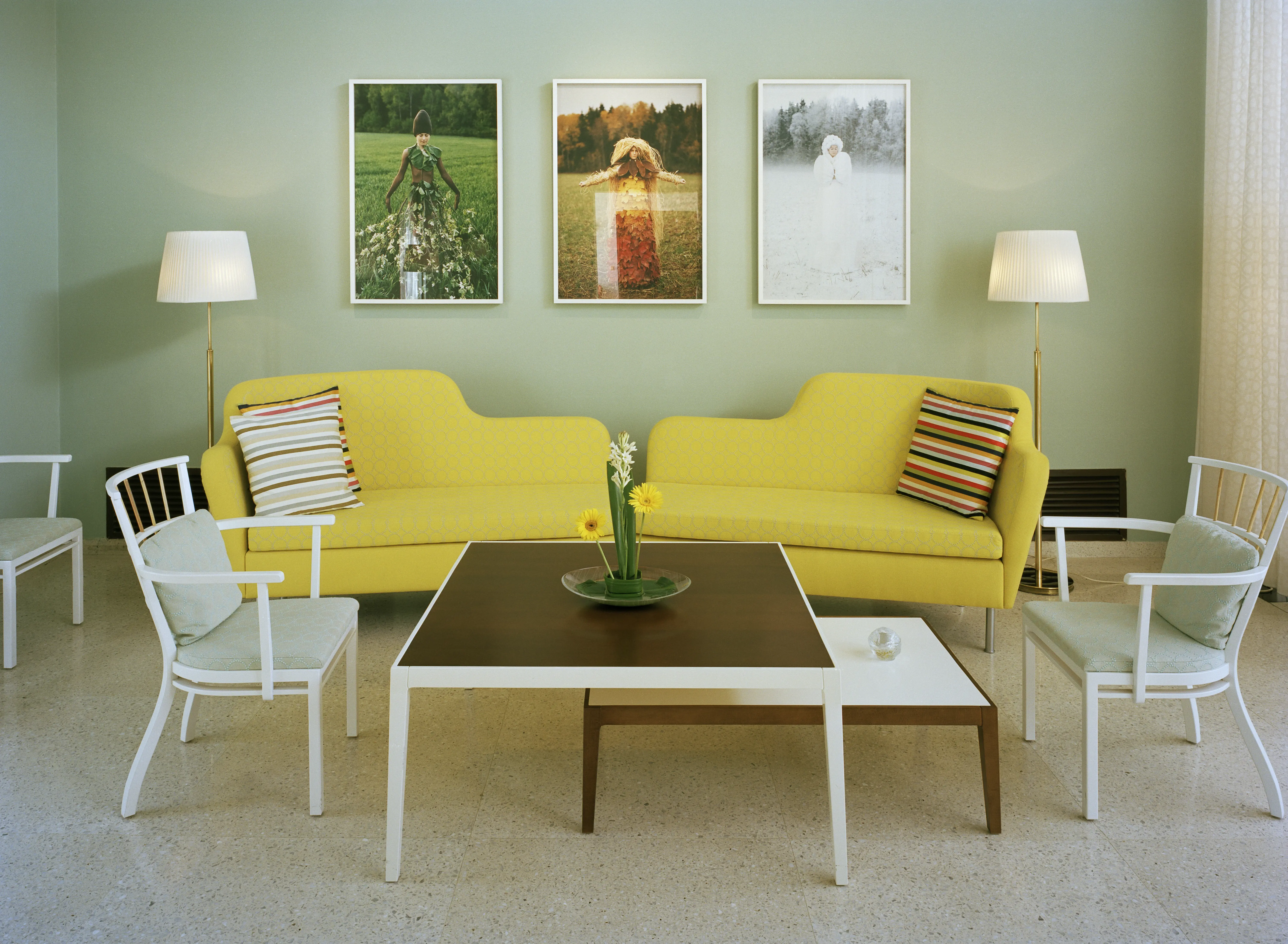 Interiör, ambassaden i New Delhi. Enkel sitt-grupp med knall-gula schäslonger och randiga kuddar. Väggen är milt grön.