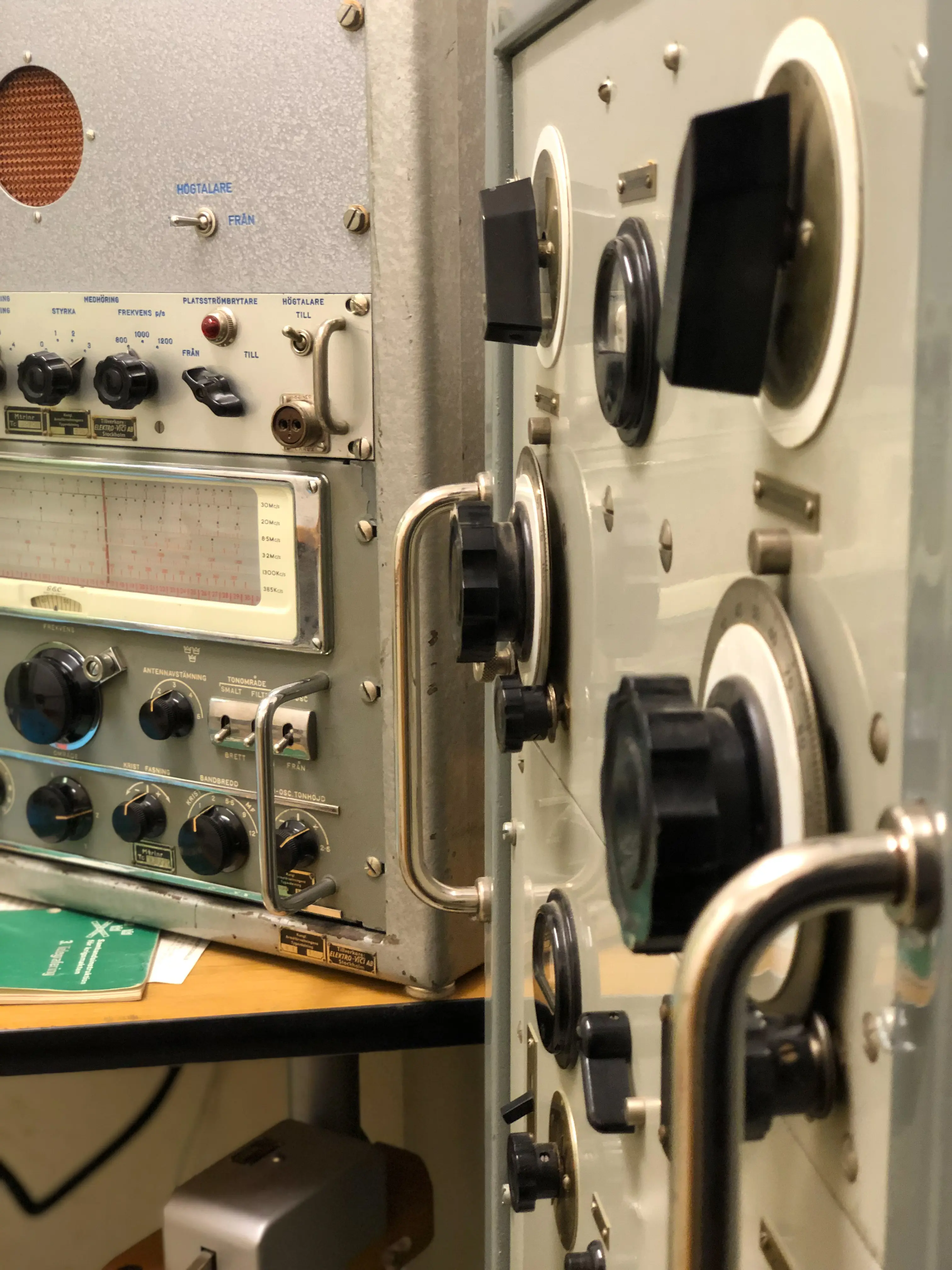 Närbild på kommunikationsutrustning i grått metalhölje. Rattar och reglage är svarta.