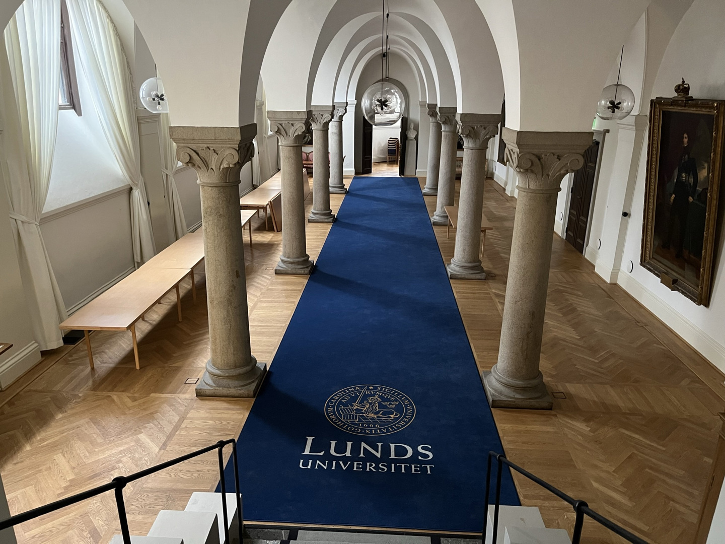 Korridor med pelare och en lång blå matta med texten "Lunds universitet".