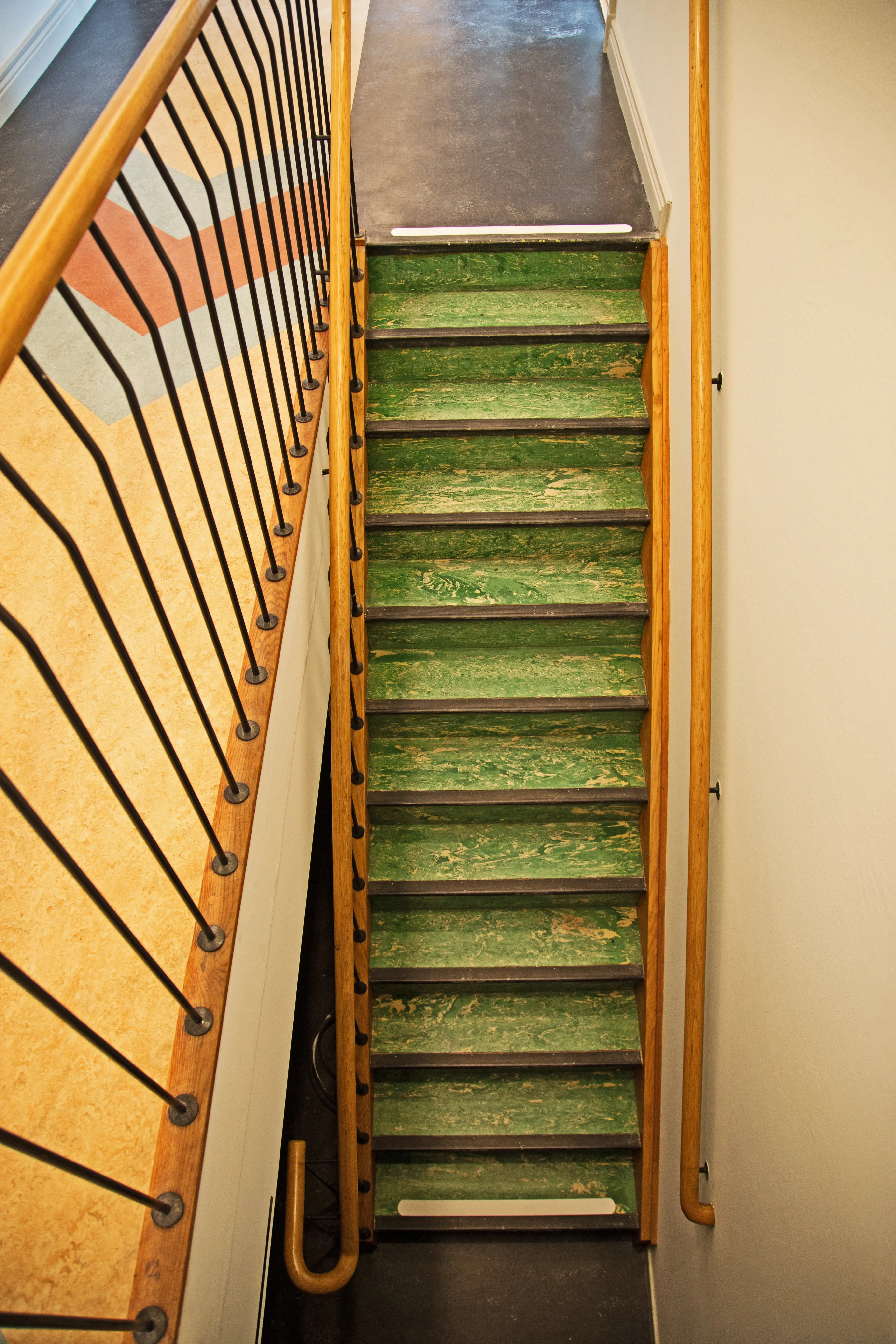 Trappa i Gamla auktionsverket, med träräcken och grön linoleum-matta.