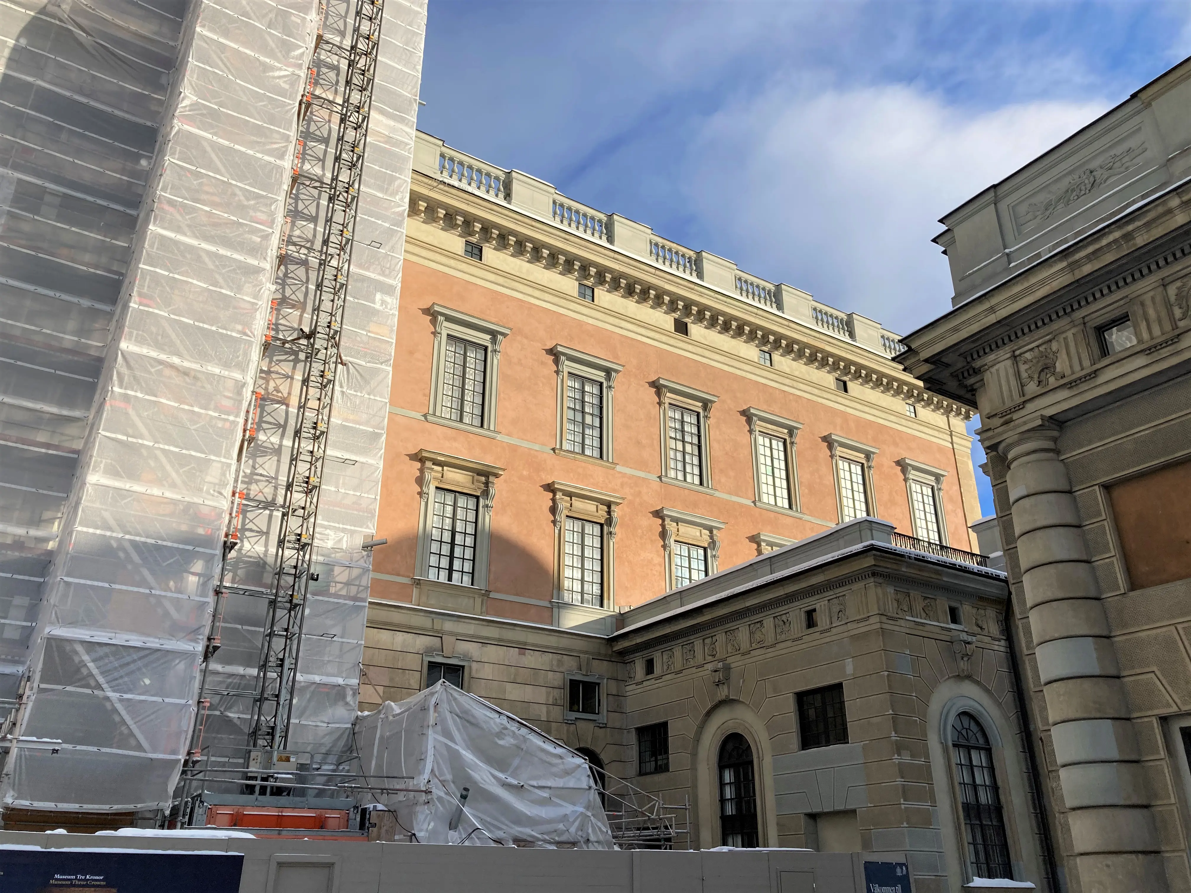 Bild på slottets västra fasad, tagen nerifrån marken. Till vänster täcker en byggnadsställning stor del av fasaden, till höger i bild den del av slottet som är färdigrestaurerat.