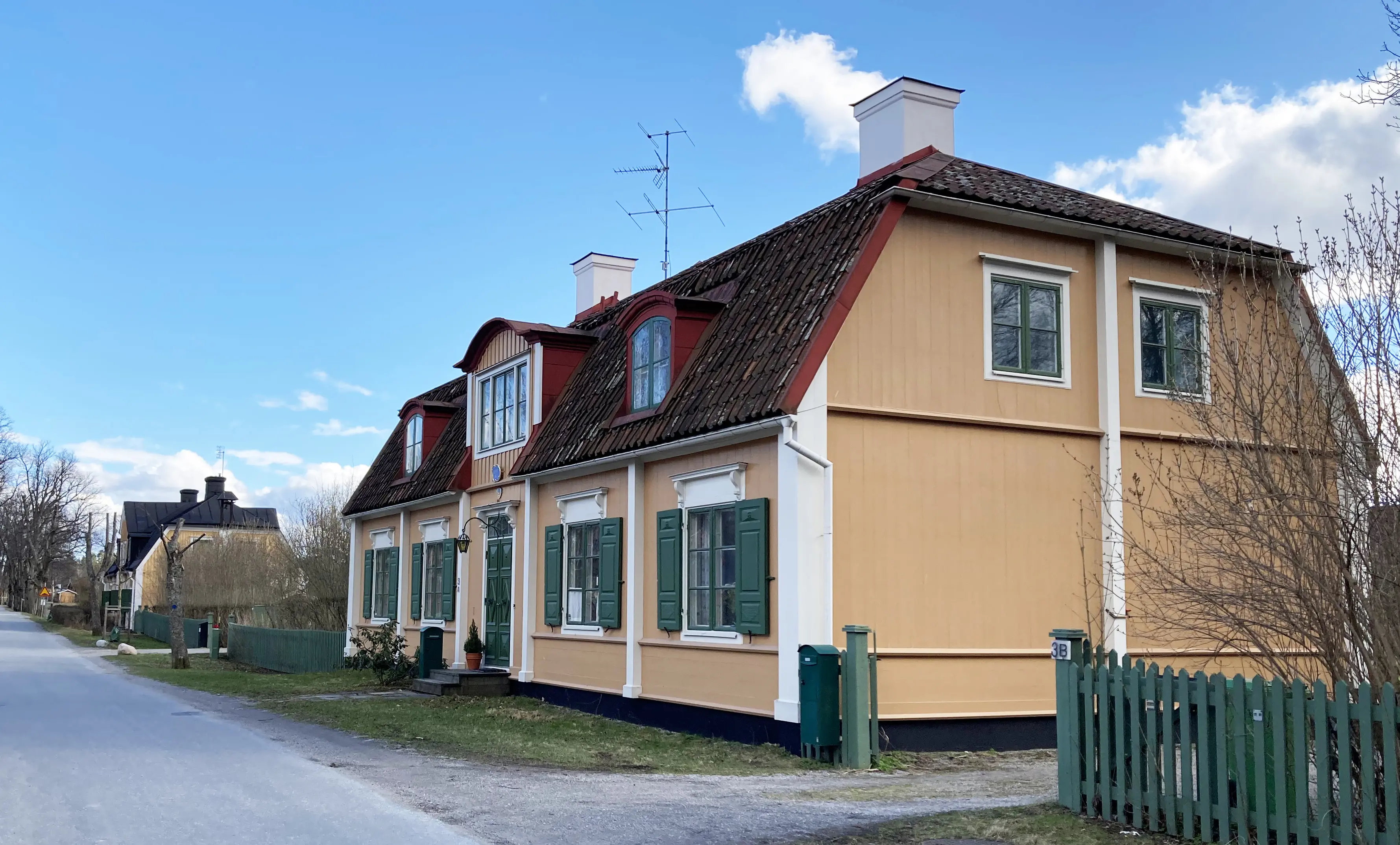 Kanton 3. Gult hus med gröna fönsterluckor. Tegeltaket har tre tak-kupor.