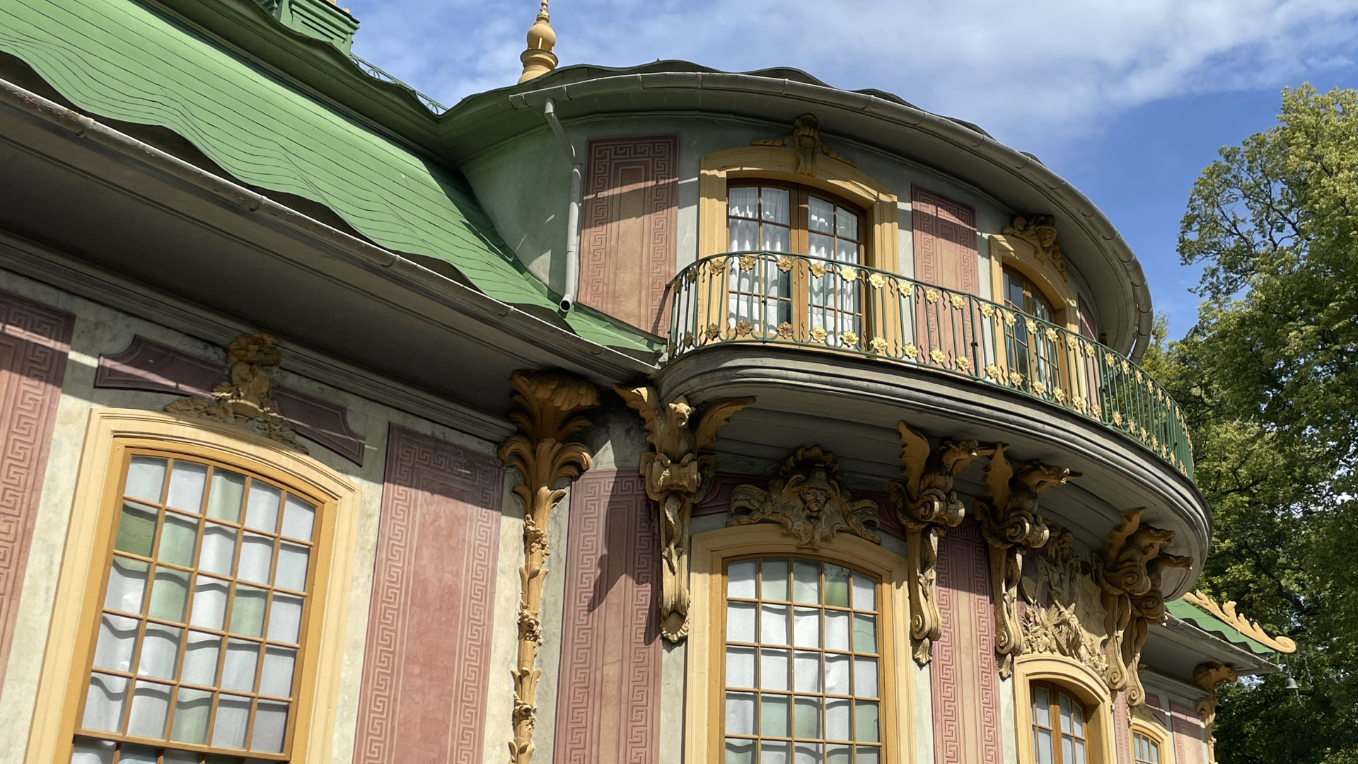 Kina slott, Drottningholm. Slottets rundade mitt-del med gul stuck-dekor och balkong med förgyllda blommor.