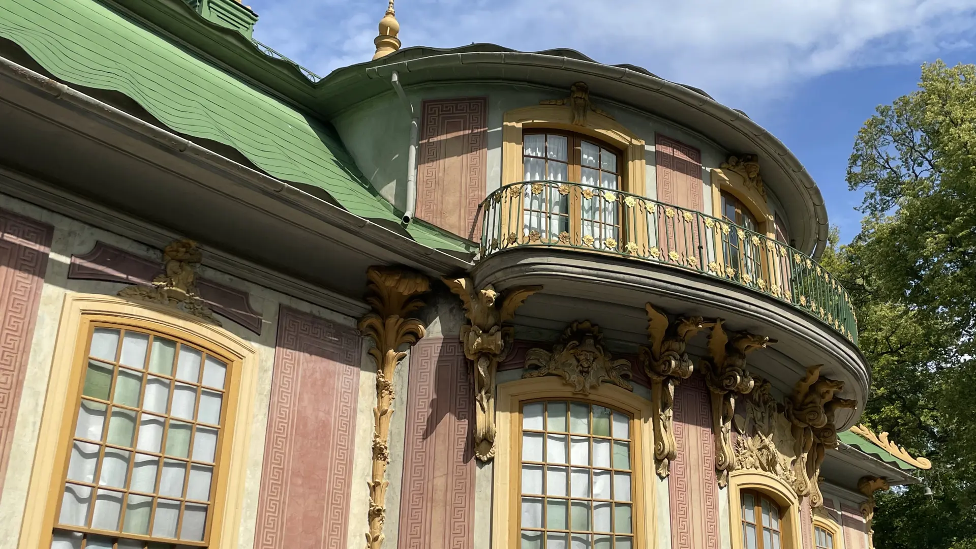 Kina slott, Drottningholm. Slottets rundade mitt-del med gul stuck-dekor och balkong med förgyllda blommor.