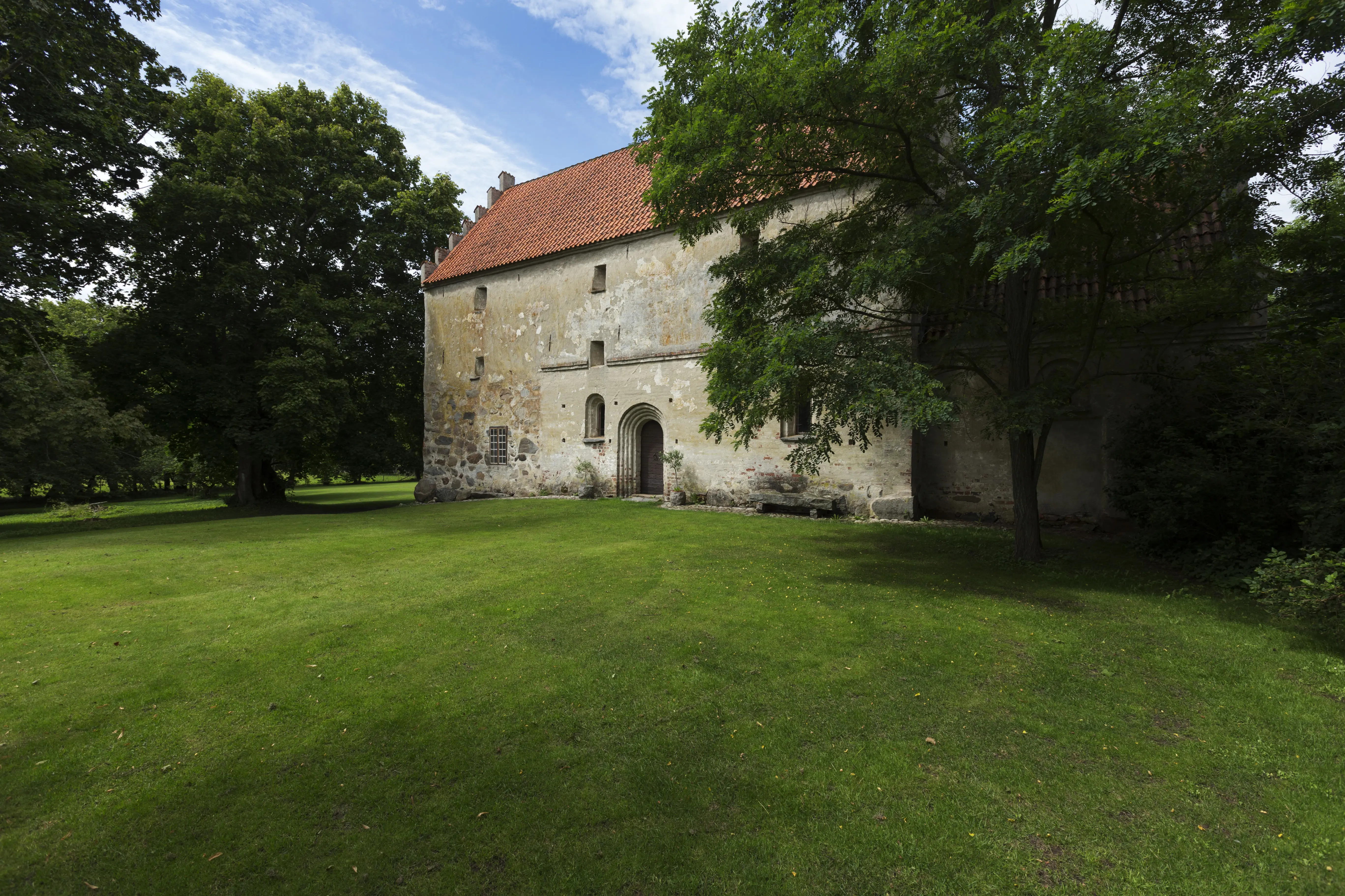 Araslövs gamla kyrka omgiven av grönska.