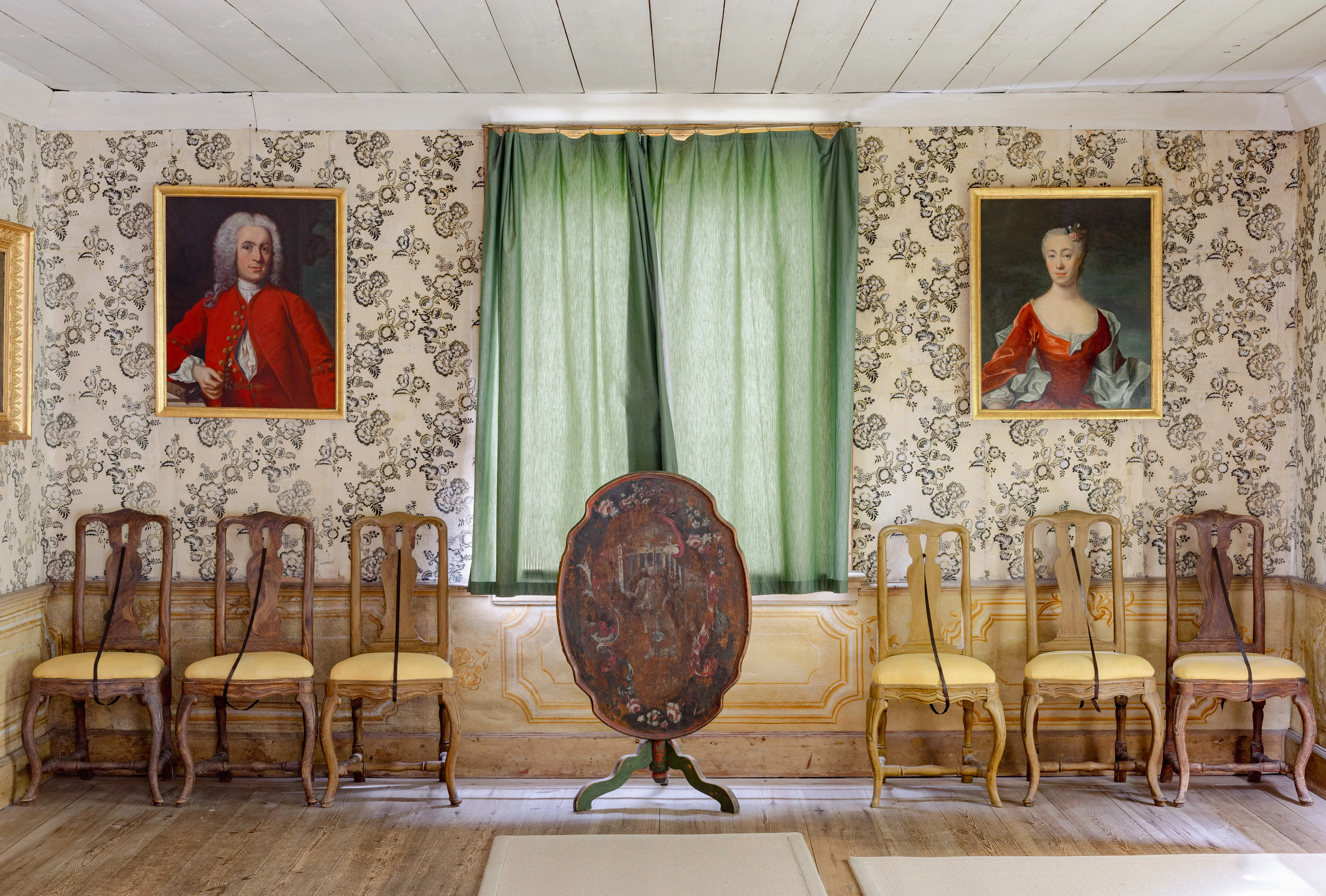 Sara Elisabeths förmak på Linnés Hammarby. Väggarna har en tapet med svart blom-tryck. Framför ett fönster står ett fällbart bord med oval, bemålad skiva.