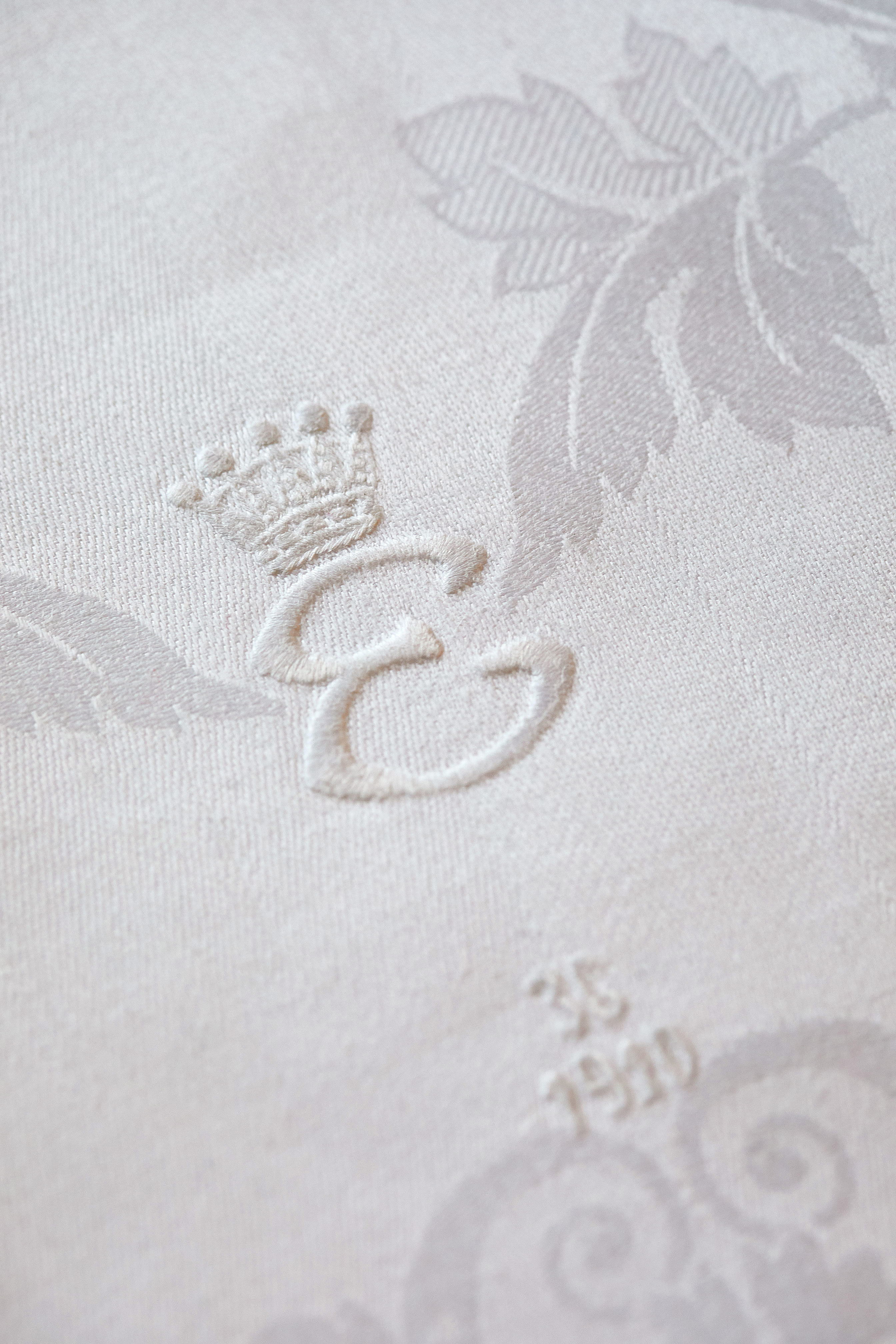 Detalj från linneservett med broderat E och årtalet 1910.