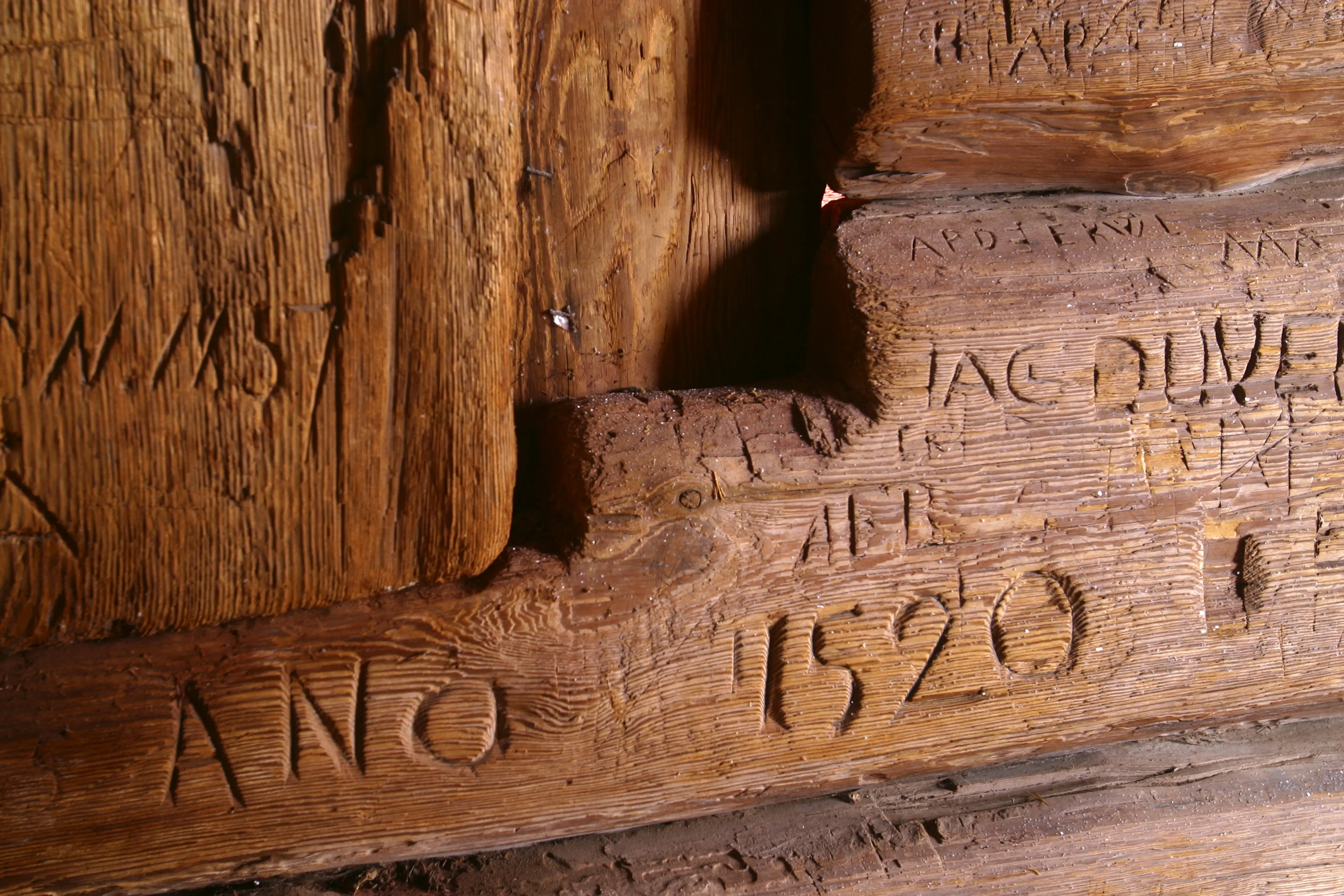 Rankhyttan, interiör. Detalj av en timmervägg med inristade namn och årtal, bland annat "ano 1520".