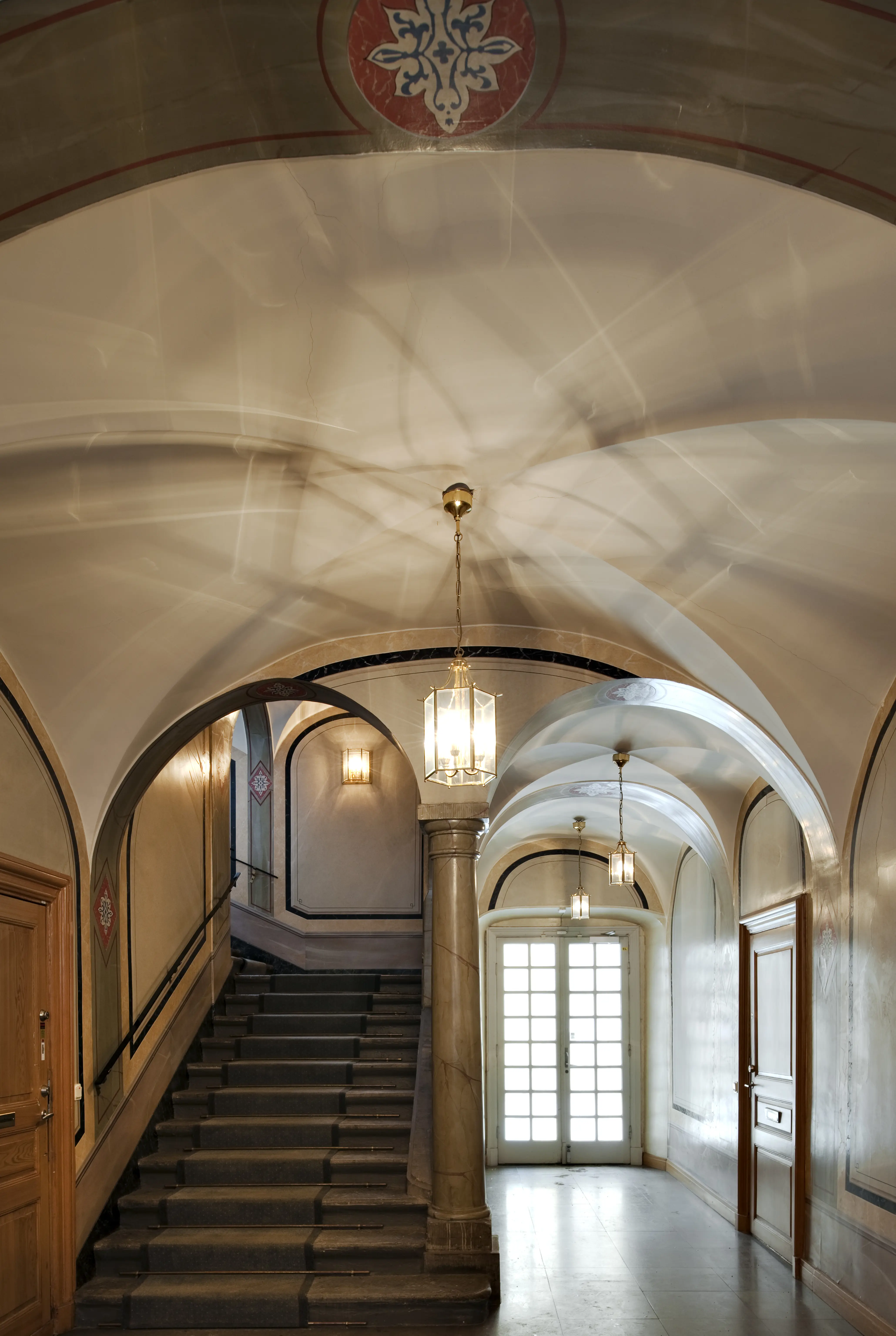 Trapphall i Utrikesministerhotellet. Taket har kryssvalv. Väggarna har ljusa marmorerade fält och grön och röd dekormålning.