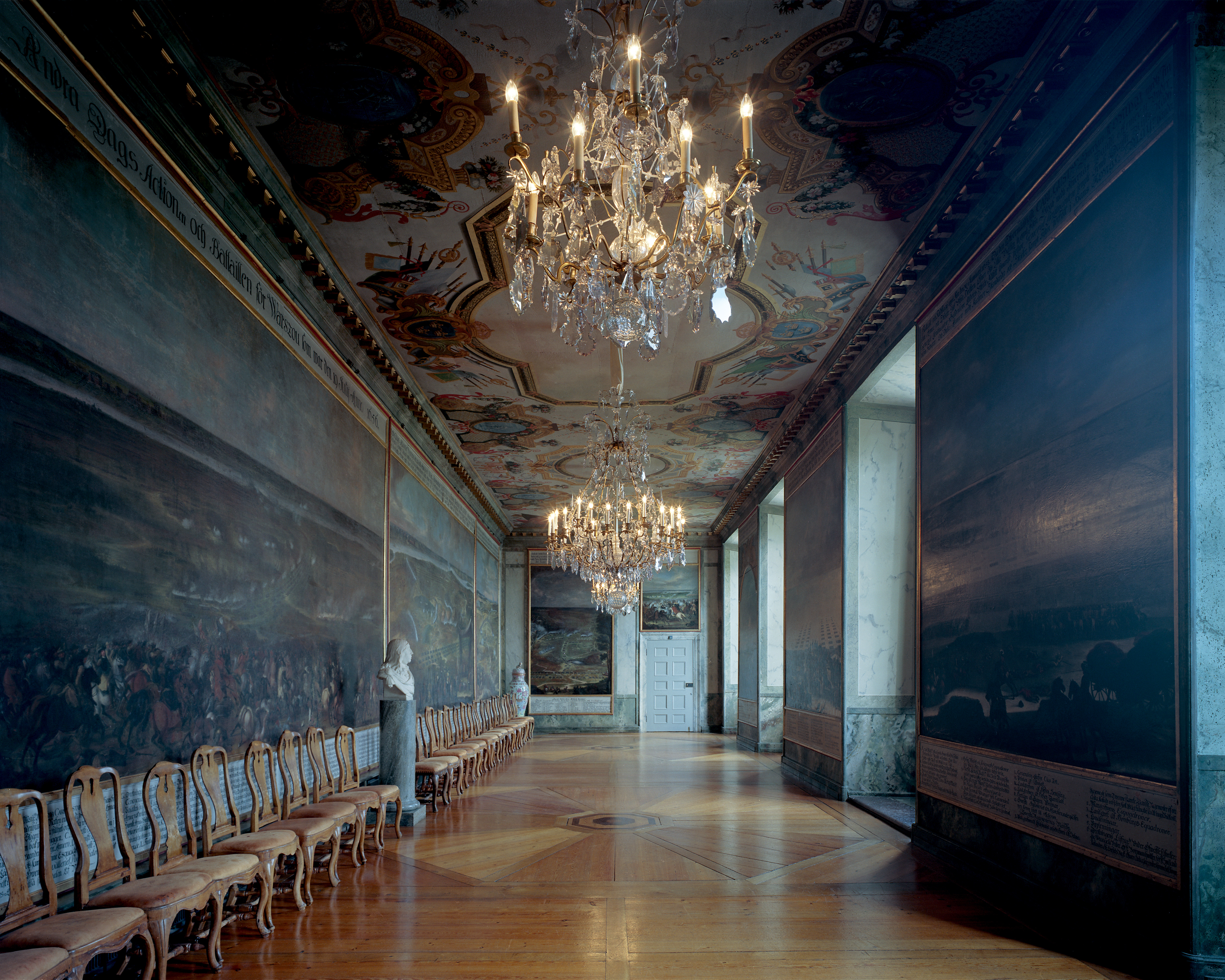 Karl den tionde Gustavs galleri i Drottningholms slott. Väggar och tak är målade med militära motiv. Stora kristall-kronor hänger i taket.