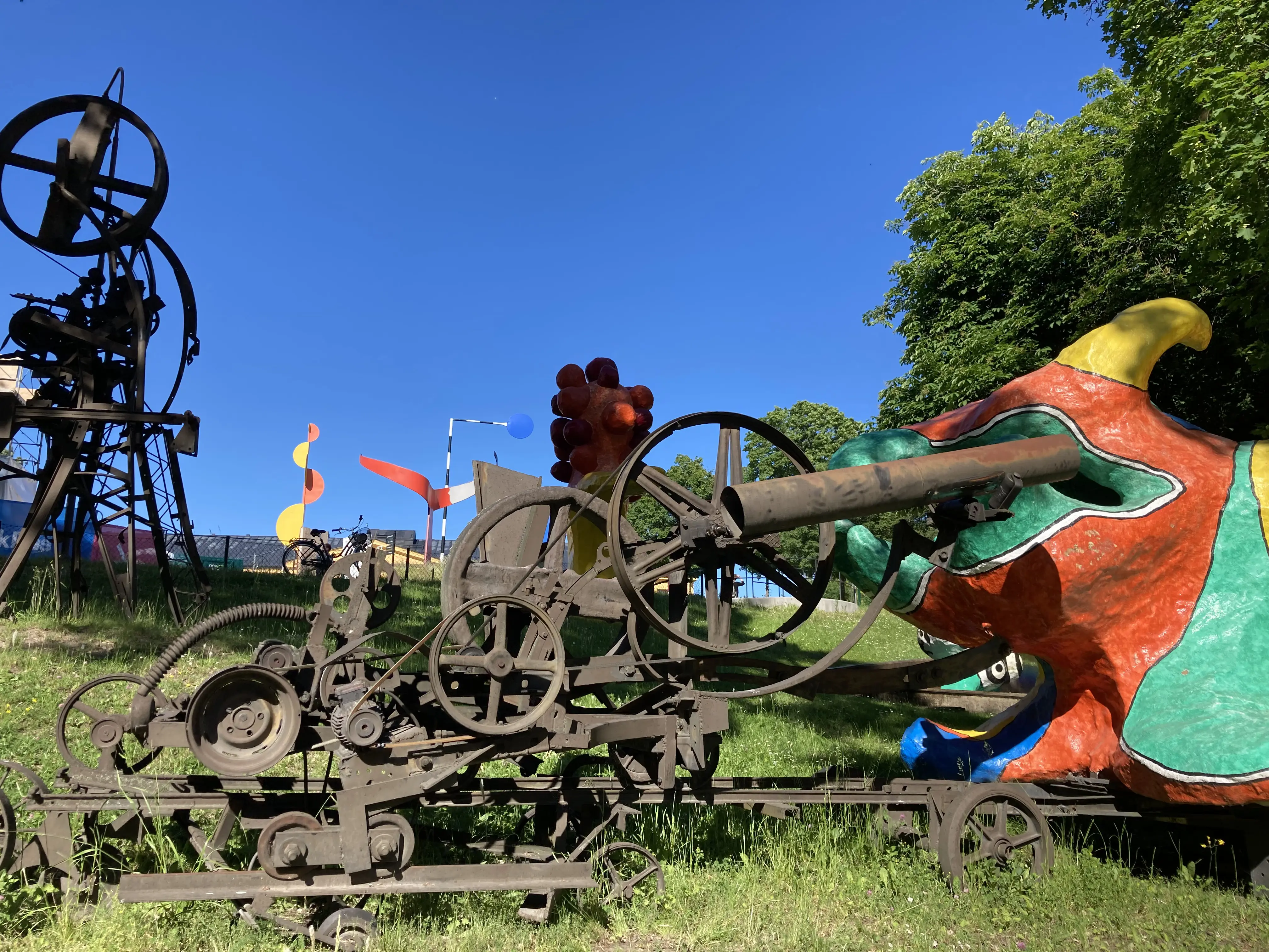 Skulpturparken utanför Moderna museet. Mekaniska skulpturer av svart järn och färg-glada, mjuka skulpturer av glasfiber.