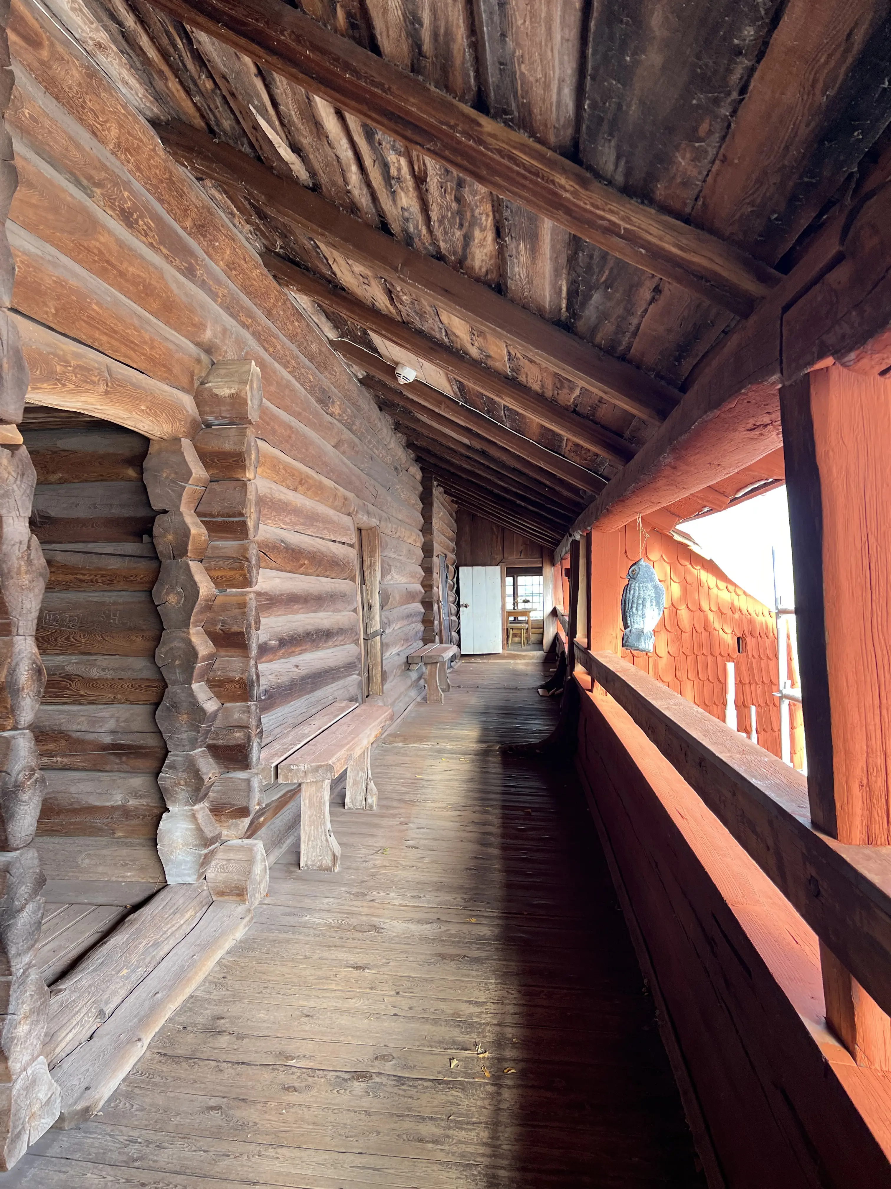 Ornässtugans övre loftgång med omålad timmerpanel till vänster och målad ytterpanel till höger.