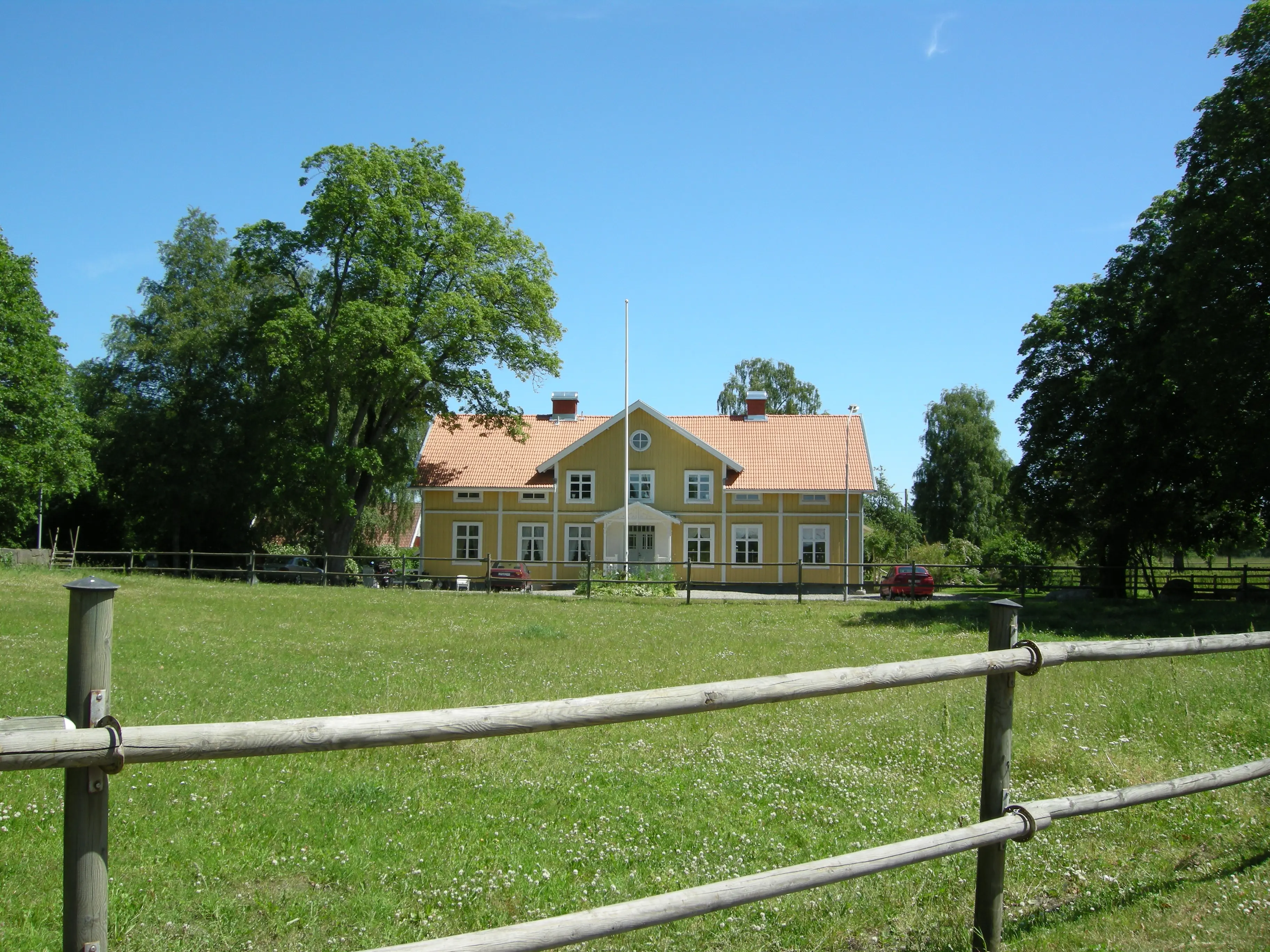 Bostadshuset, Kronobergs kungsgård. Tvåvåningshus i gulmålat trä.