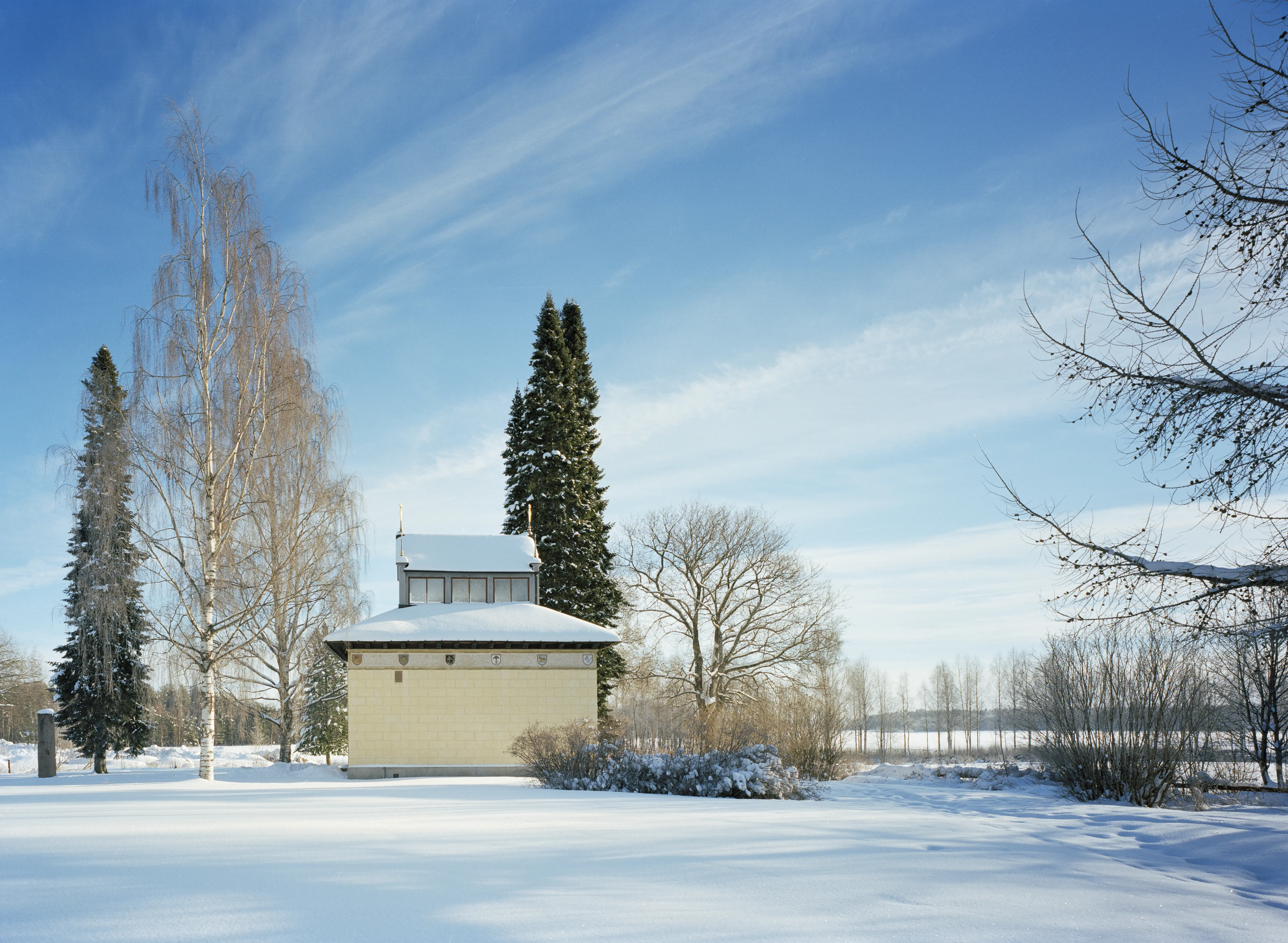 Vasamonumentet i ett vinterlandskap. En gul liten byggnad med en husformad lanternin på taket.