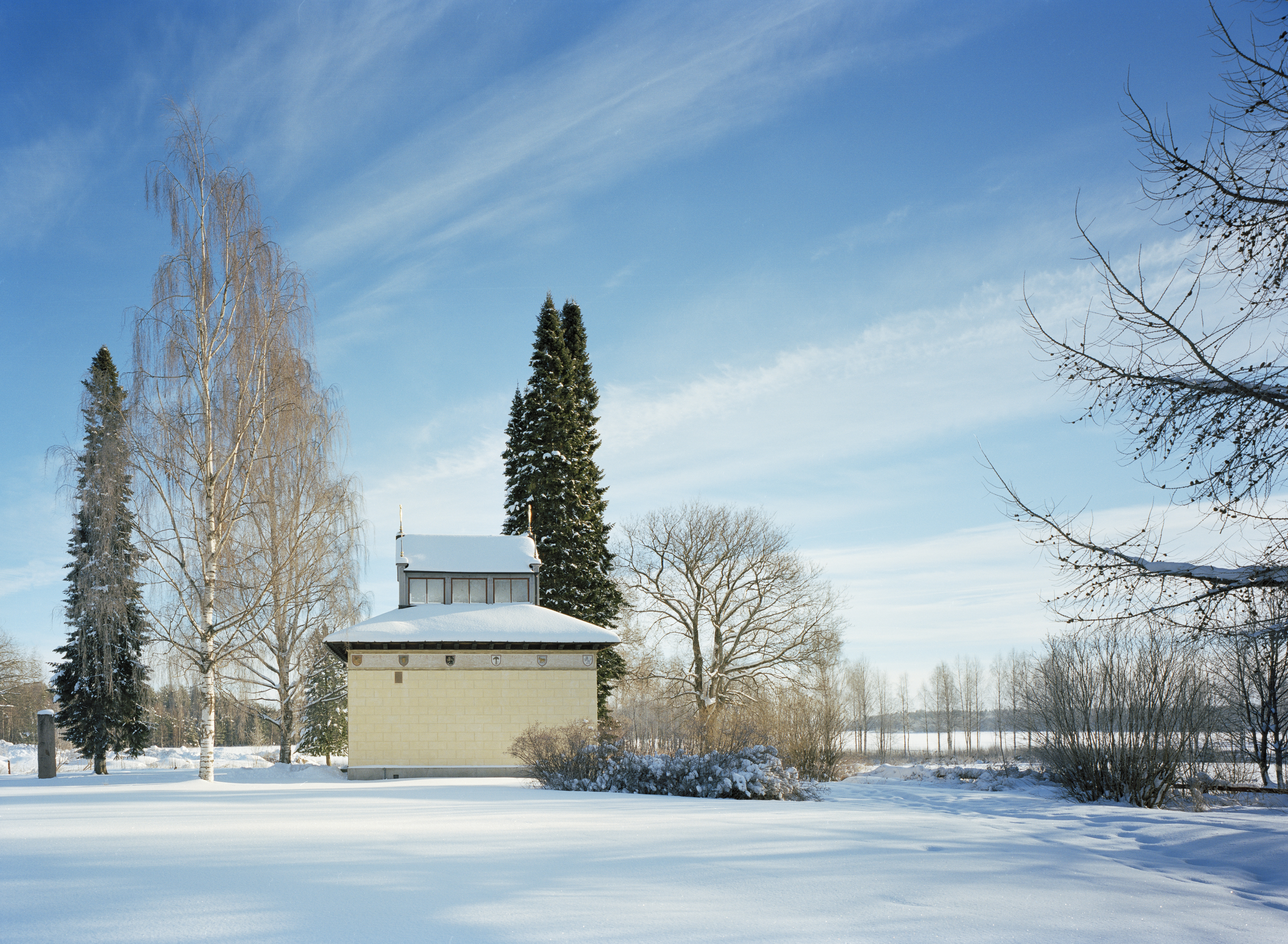 Vasamonumentet i ett vinterlandskap. En gul liten byggnad med en husformad lanternin på taket.