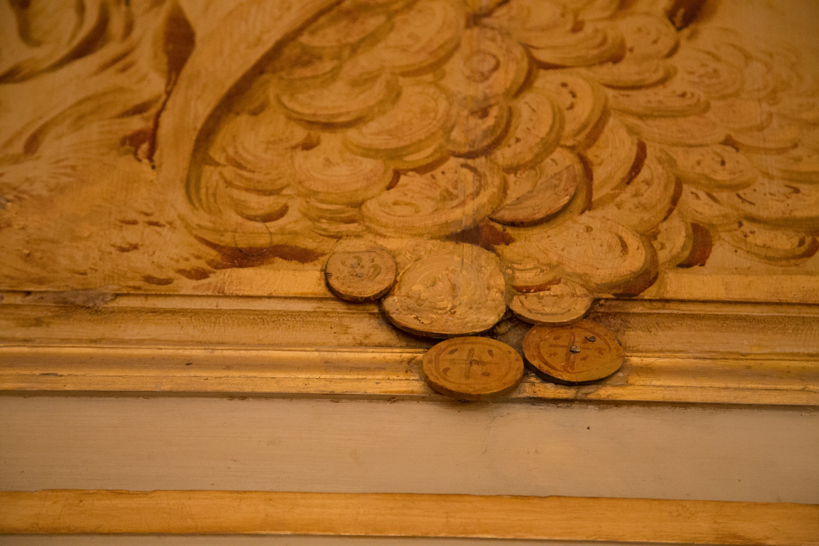 När bild på dörröverstycke från 1770-talet. Förgyllda mynt från ett ymnighetshorn ramlar ut ur ramen.