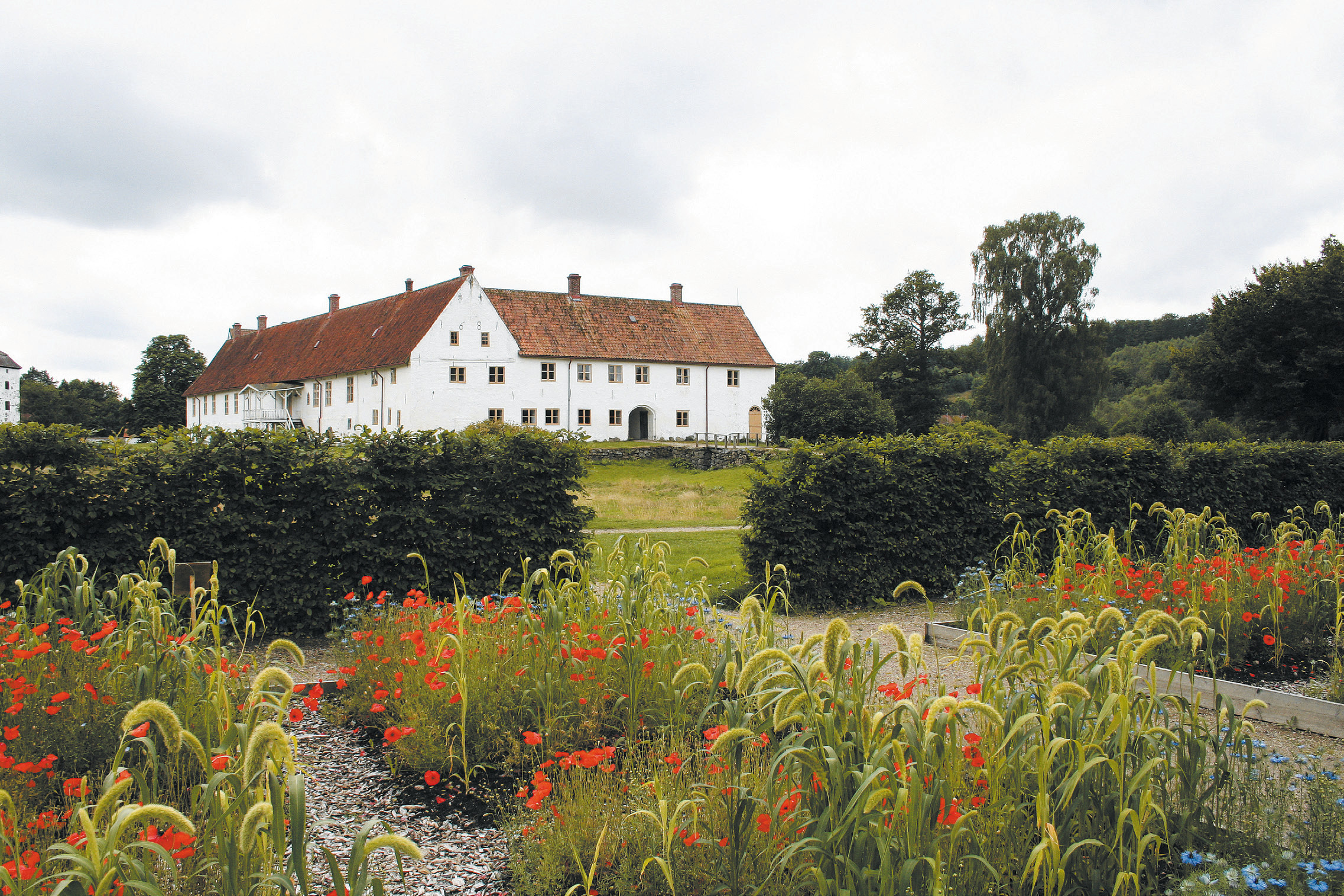 Köksträdgården i Hovdala slottspark. I bakgrunden slottet. Sommar, blommor och grönska.