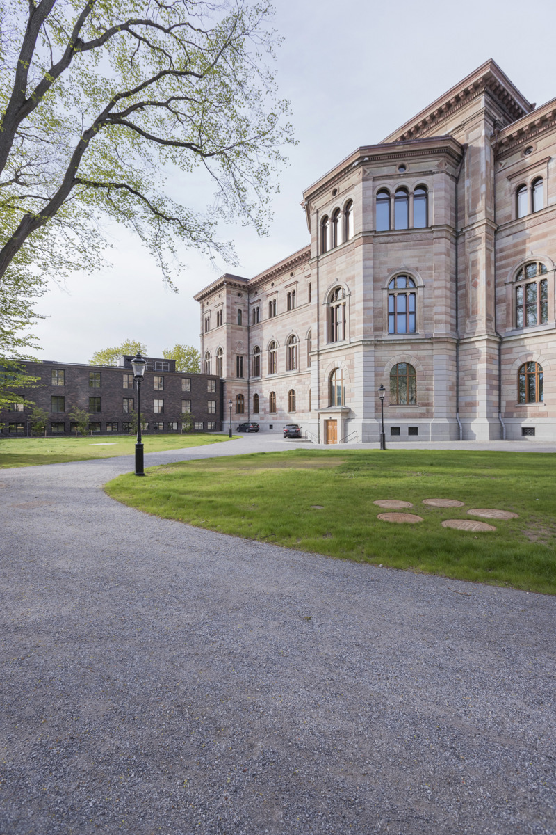 Nationalmuseum sett från baksidan med en grusväg och en gräsplan framför.