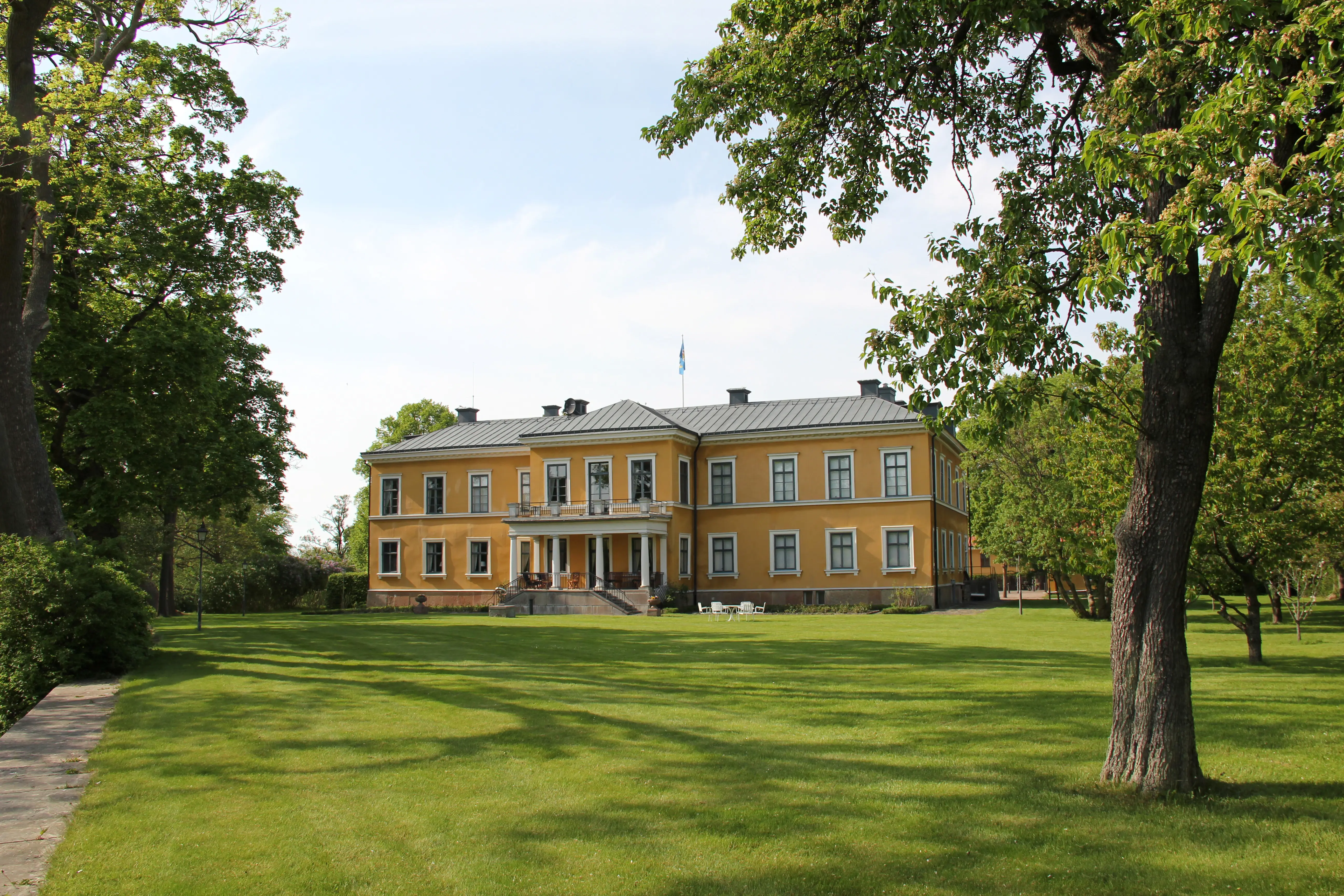 Parken och huvudbyggnaden i Marieholm. Sommar och grönska.