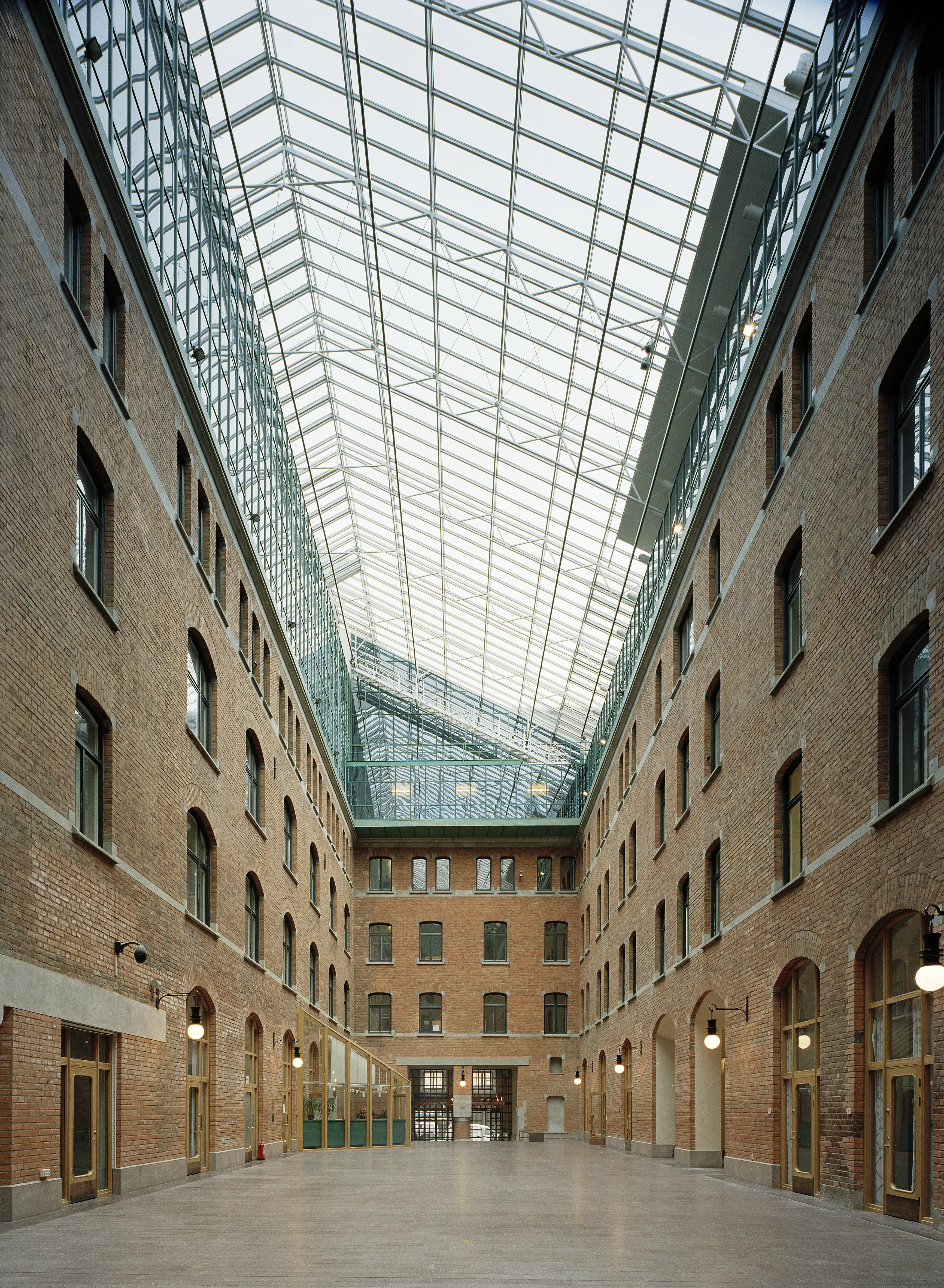 En av Centralposthusets överglasade gårdar. Husfasaderna är klädda med tegel.