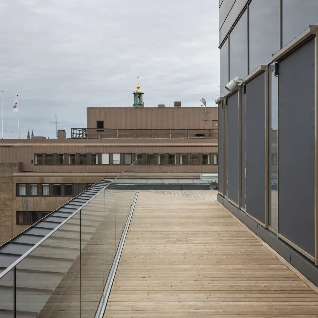 Takterrass med trädäck. I bakgrunden skymtar stadshusets torn.