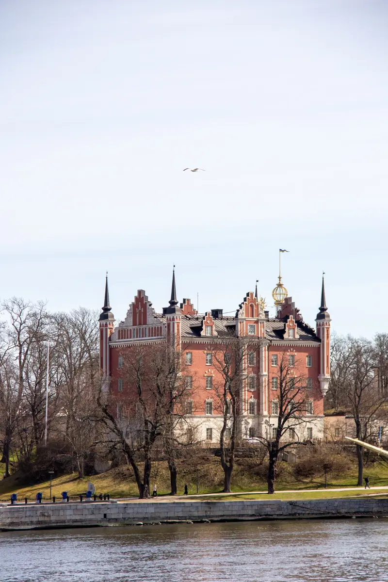 Amiralitetshuset. Brunputsad byggnad med hörntorn och praktgavlar i nyrenässans-stil. Fasaden har vita dekorationer.