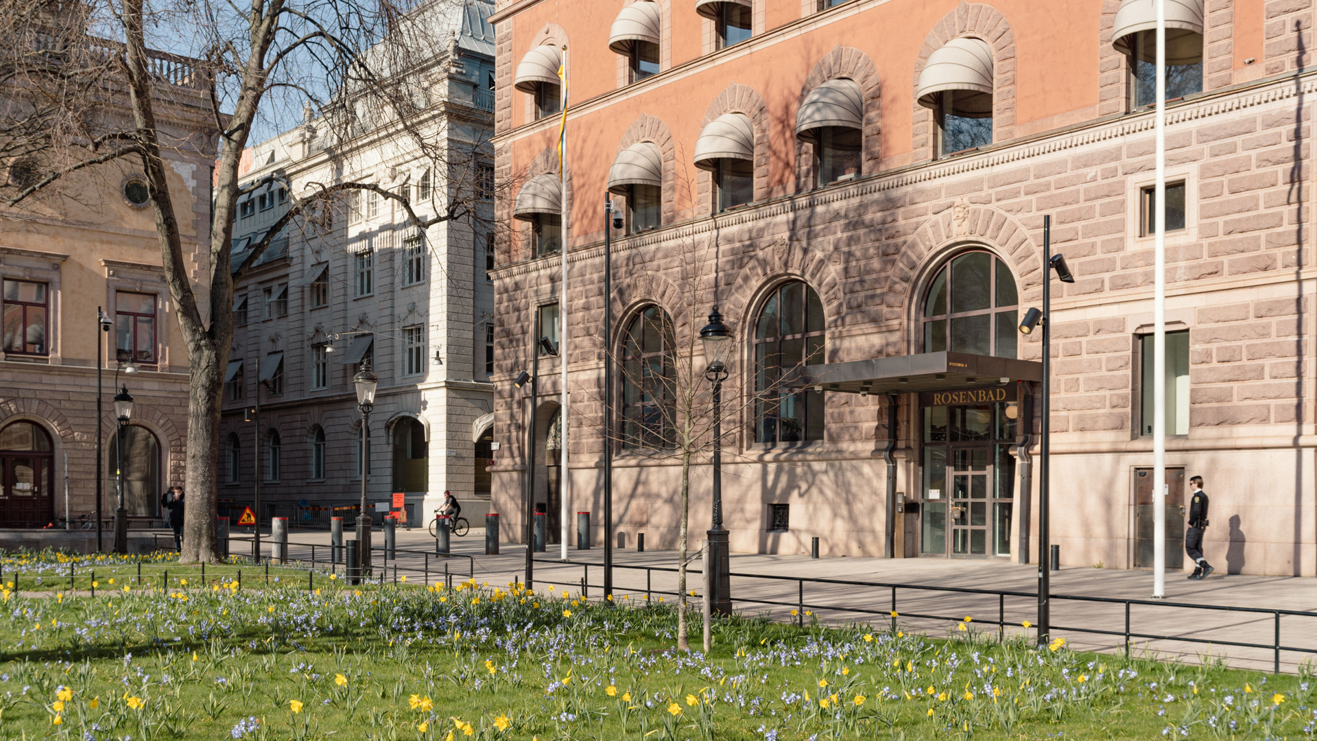 Stockholms stads sparbank och Rosenbadsparken. Fasaden är av sten och röd puts. Ovanför entrén står "Rosenbad".