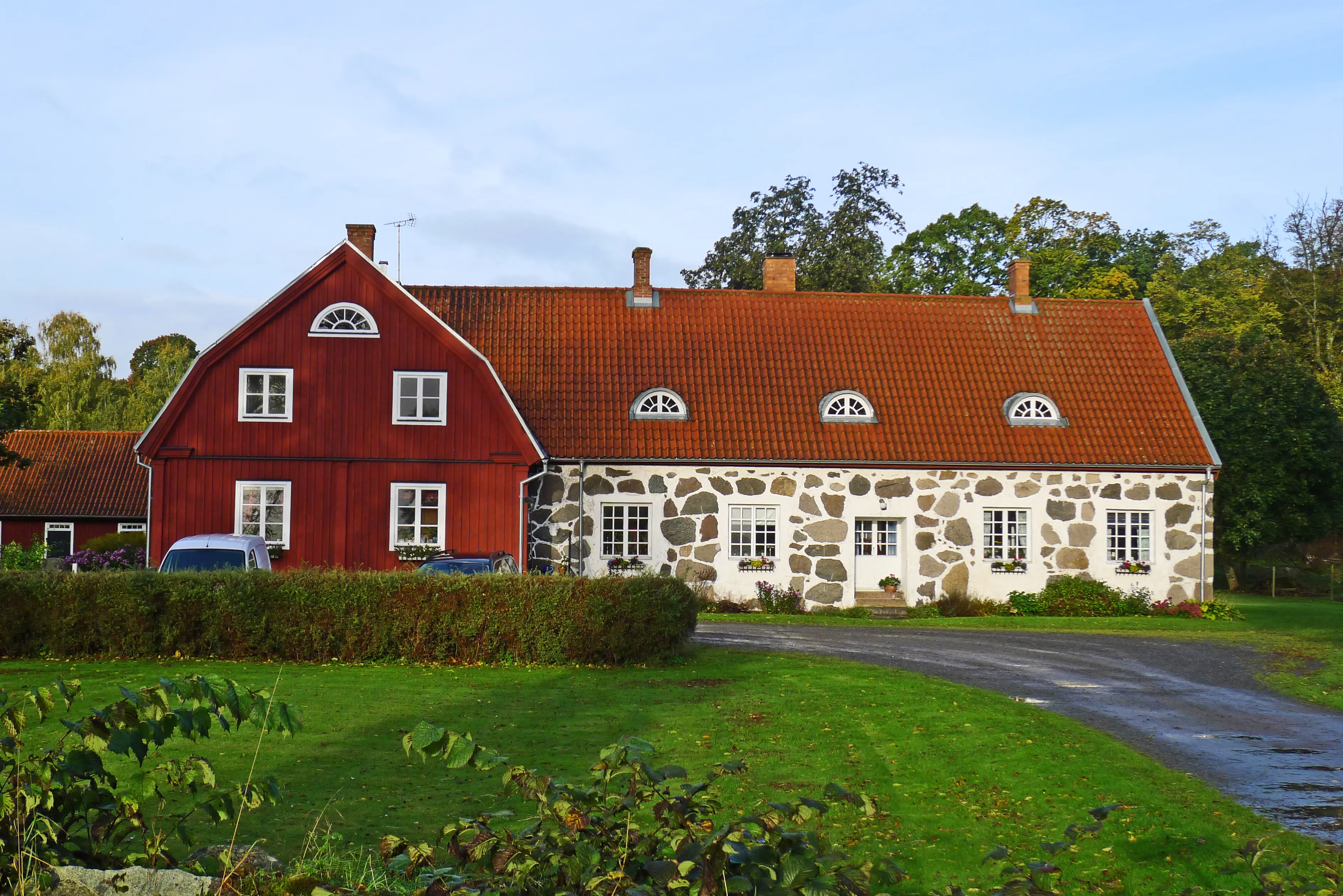 Bostadshus i sten och röd-målat trä på Bäckaskogs gård.