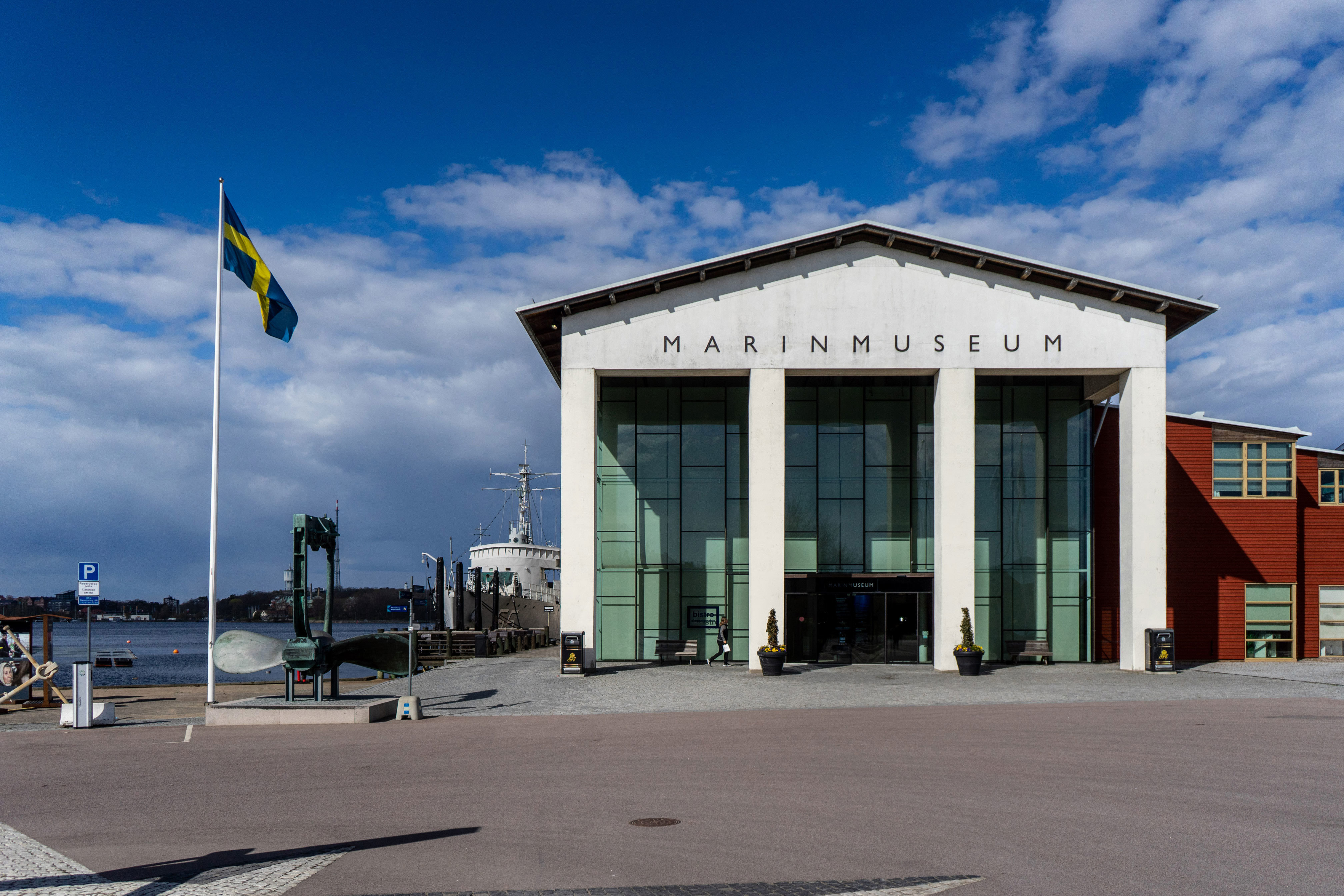 Vit byggnad med stora rektangulära glasfönster tonade i grönt.