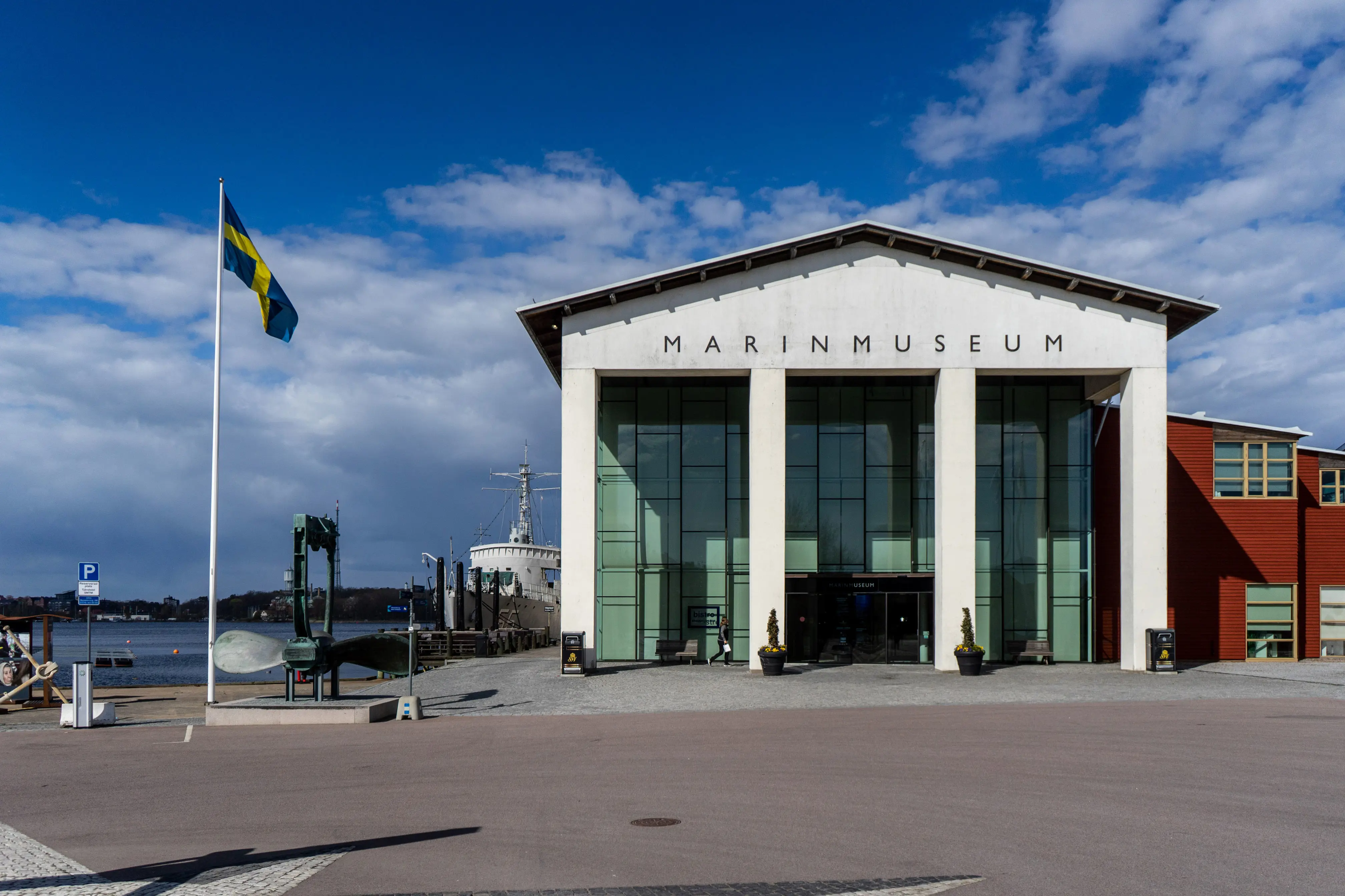 Vit byggnad med stora rektangulära glasfönster tonade i grönt.