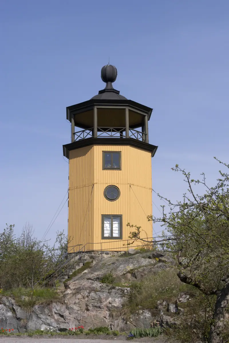 Utsiktstornet med gulmålad träfasad.