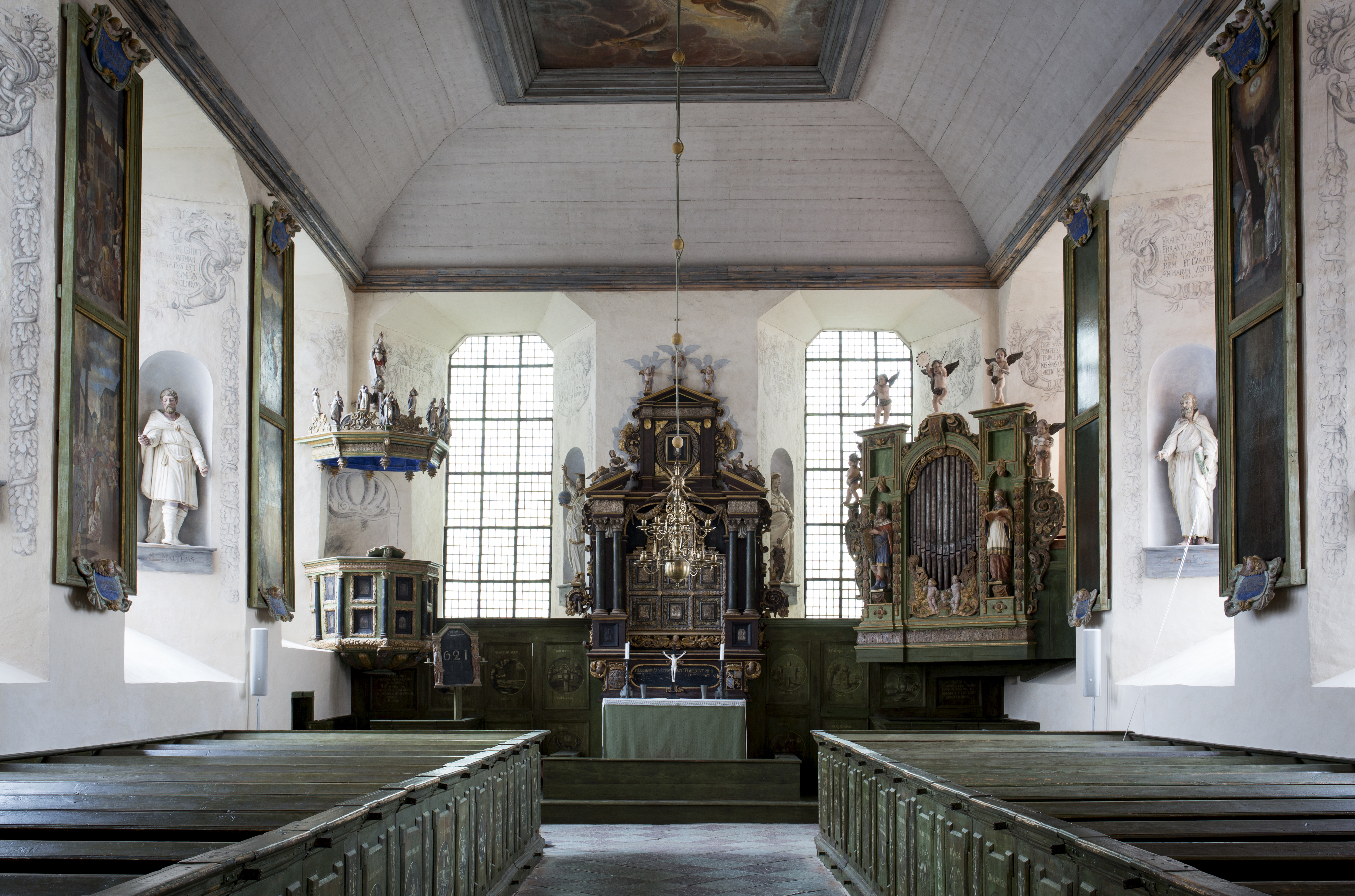 Läckö slottskyrka. Kyrkorum med väggmålningar, skulpturer och träinredning i sirlig barockstil.