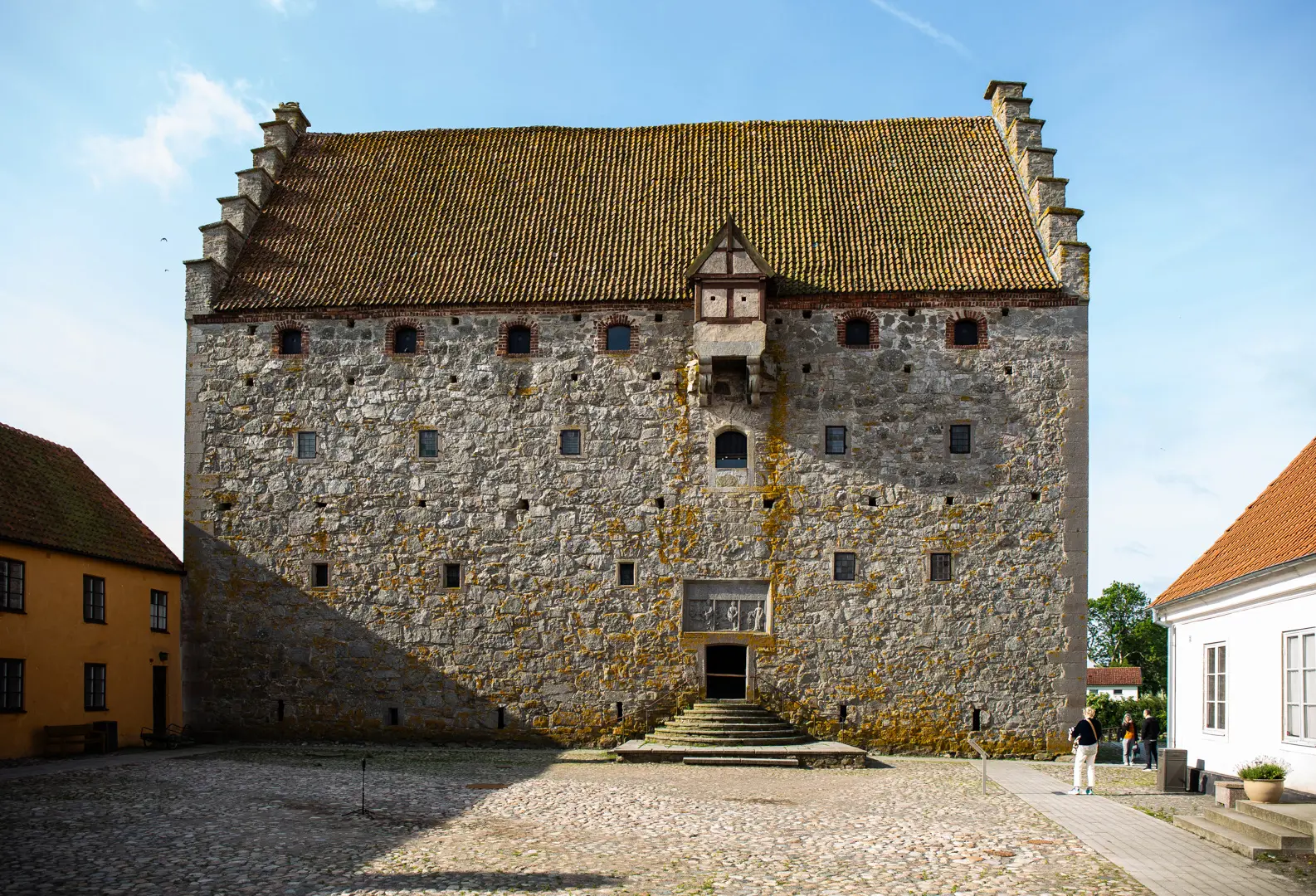 Stenborgen syns från borgården med blå himmel bakom.