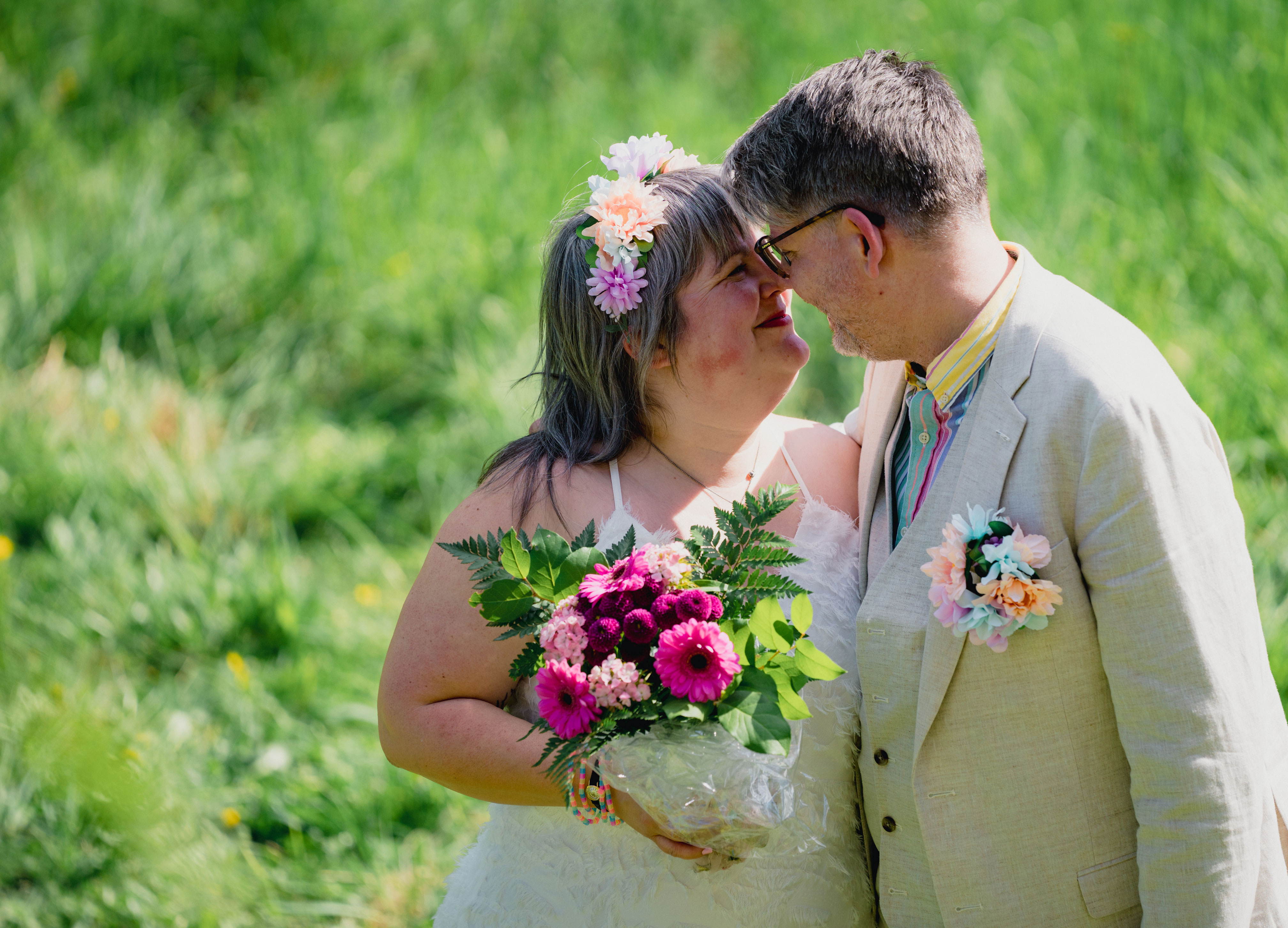 Brudpar mot grönskande bakgrund.