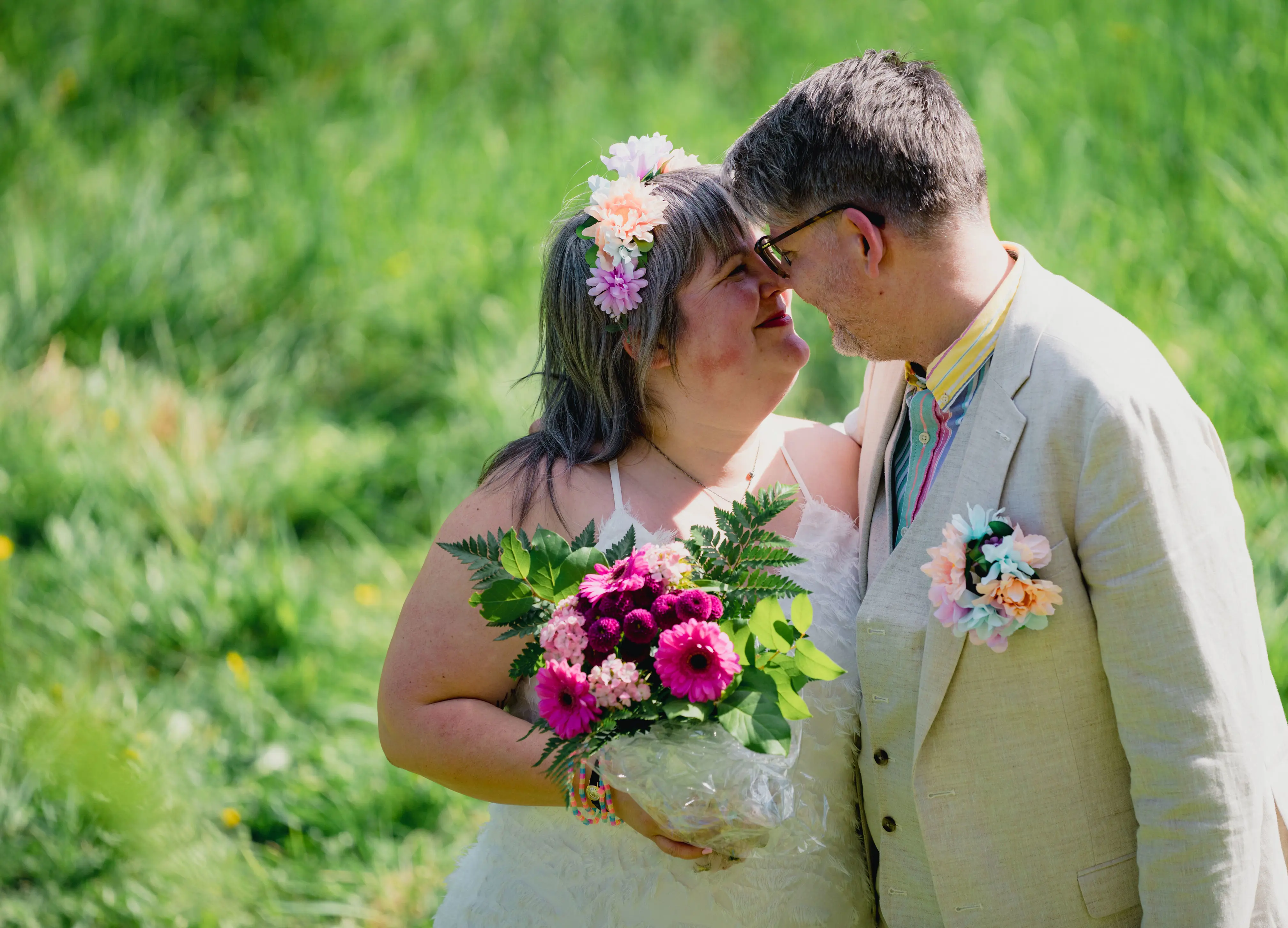 Brudpar mot grönskande bakgrund.