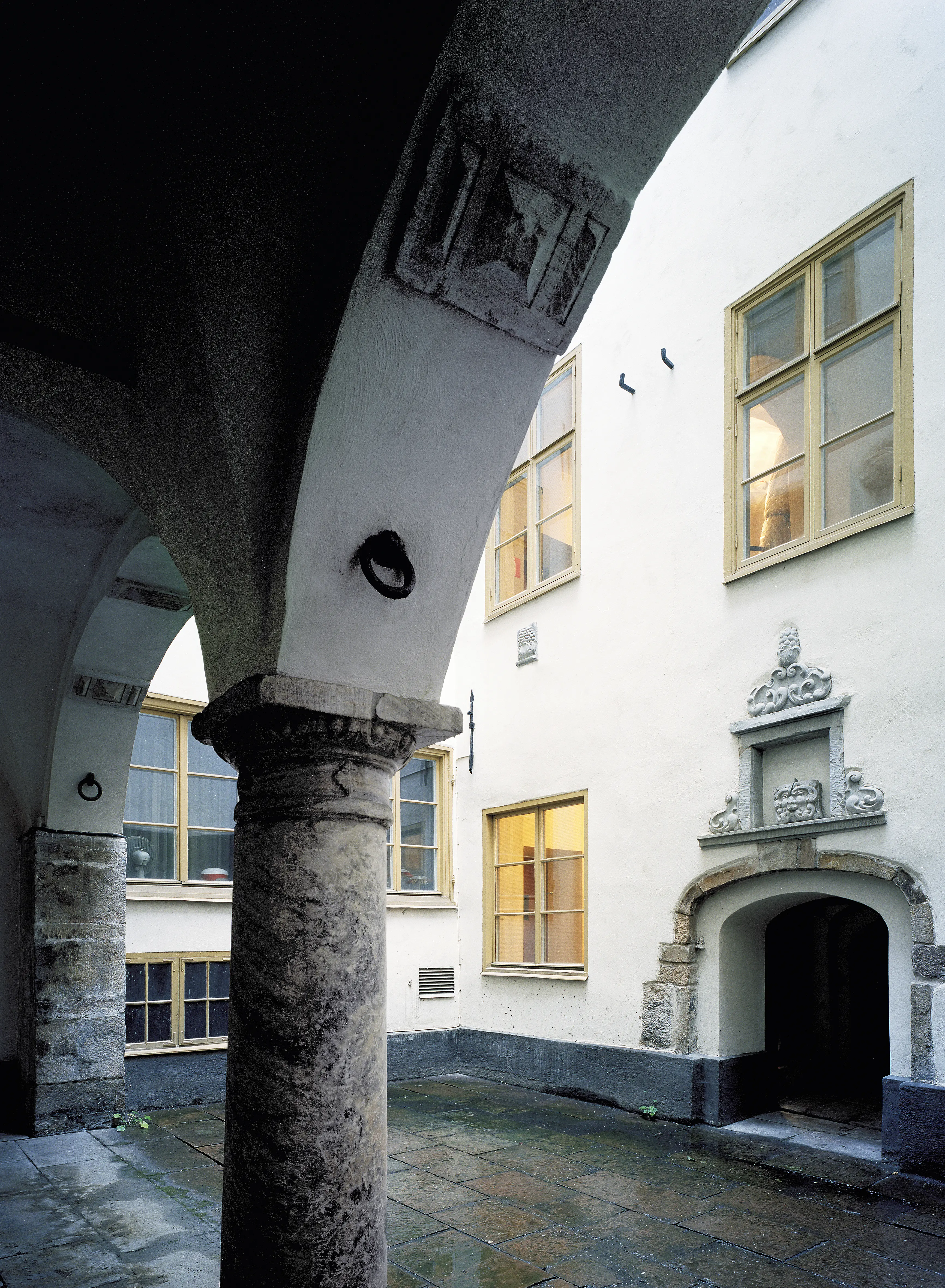 Beijerska husets stenlagda innergård med arkad och ståtlig port.