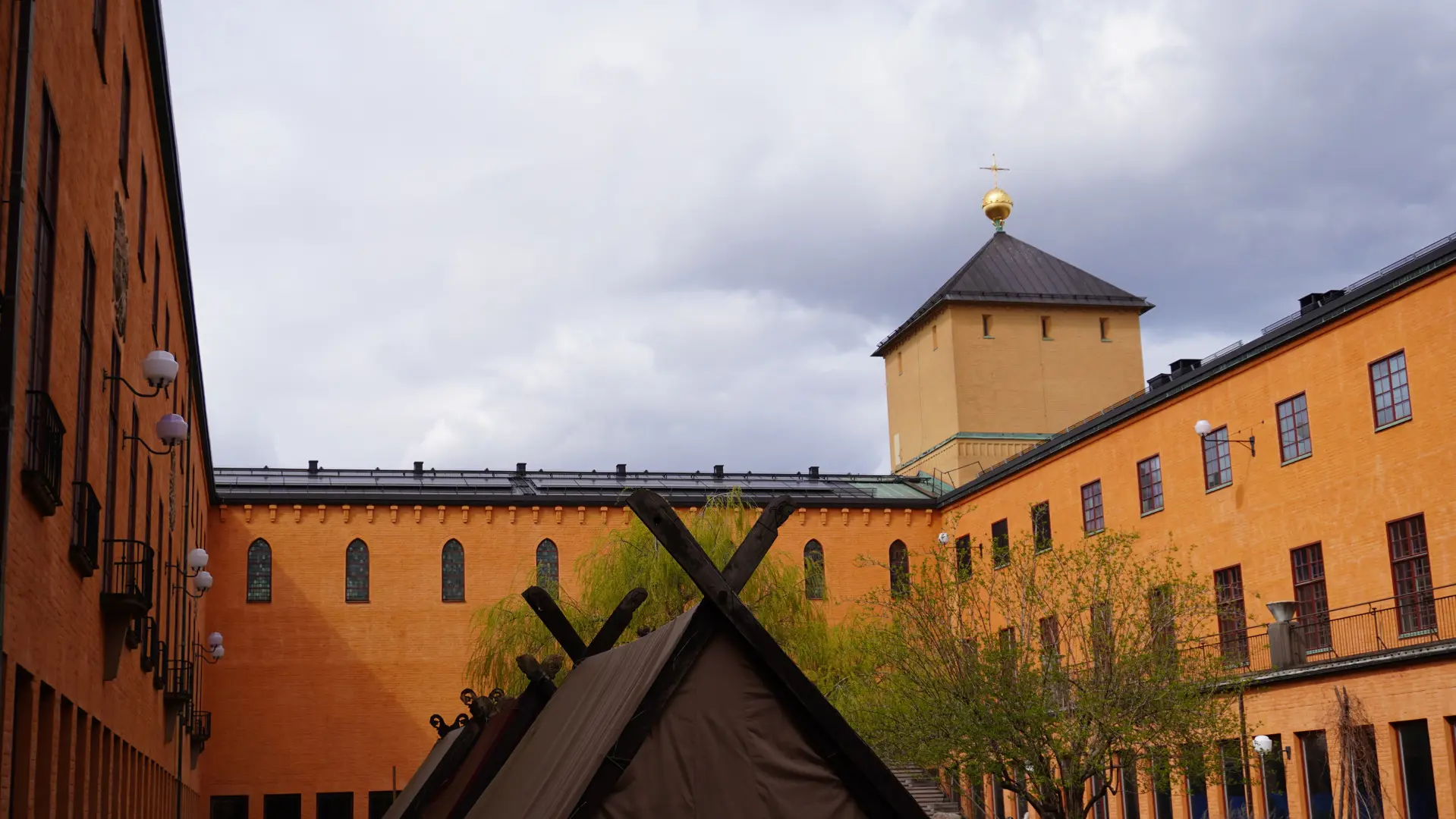 Historiska museets innergård, omgiven av gula huslängor med ett fyrkantigt torn.