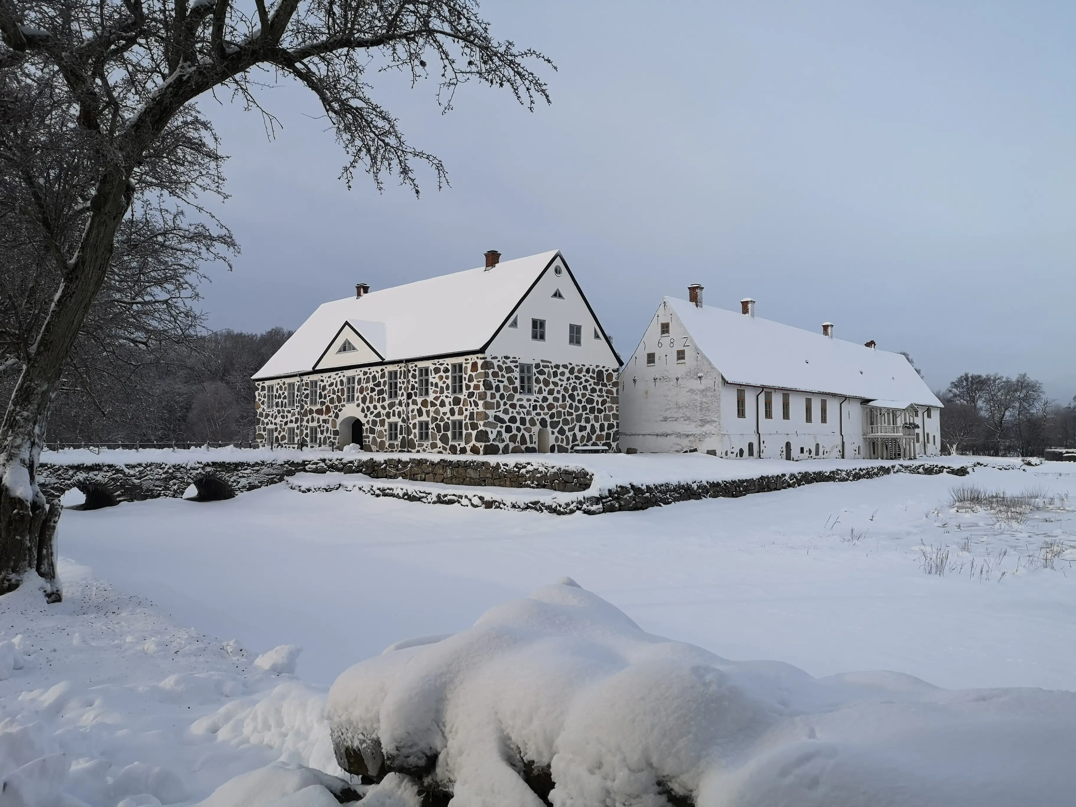 Hovdala slott inbäddat i snö. Valvbrons, terrassens, samt arrendatorflygelns stenar kontrasterar mot det vita.