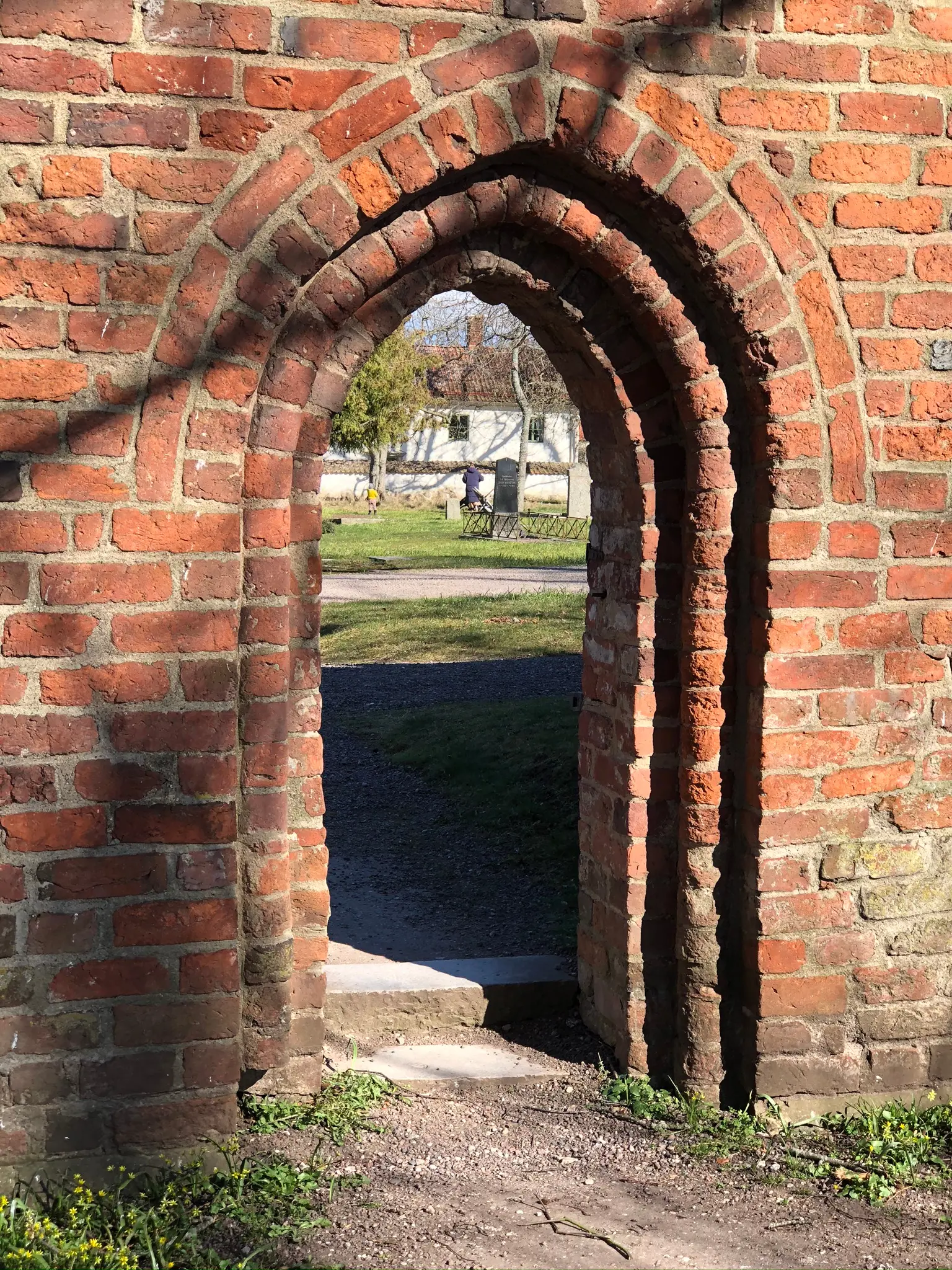 Gotisk portal i tegelmuren mellan kyrkogården och Vadstena klosterträdgård.