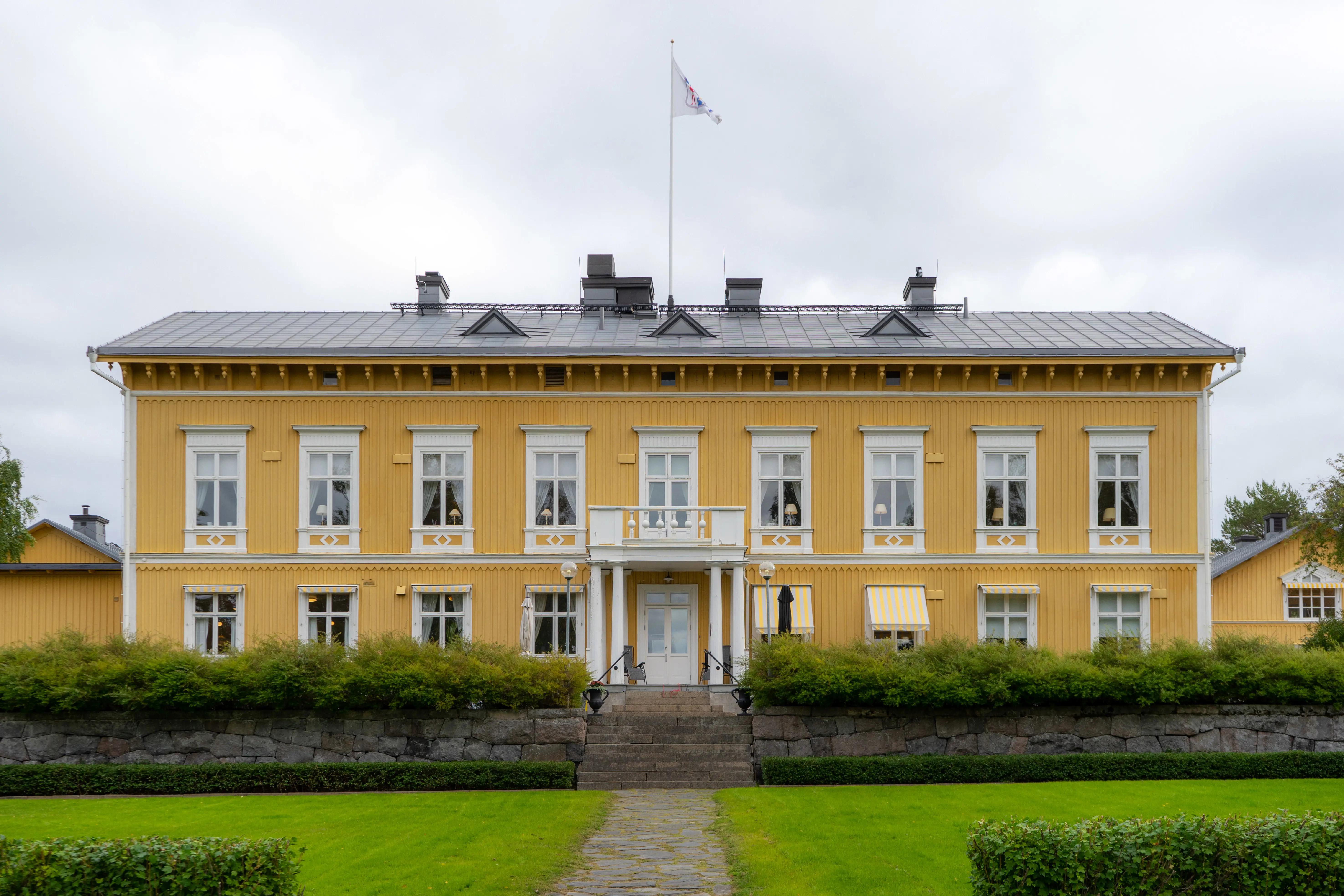 Residenset i Luleå. En gul träbyggnad i två våningar, med vita snickerier. Fasad mot parken. Höst.