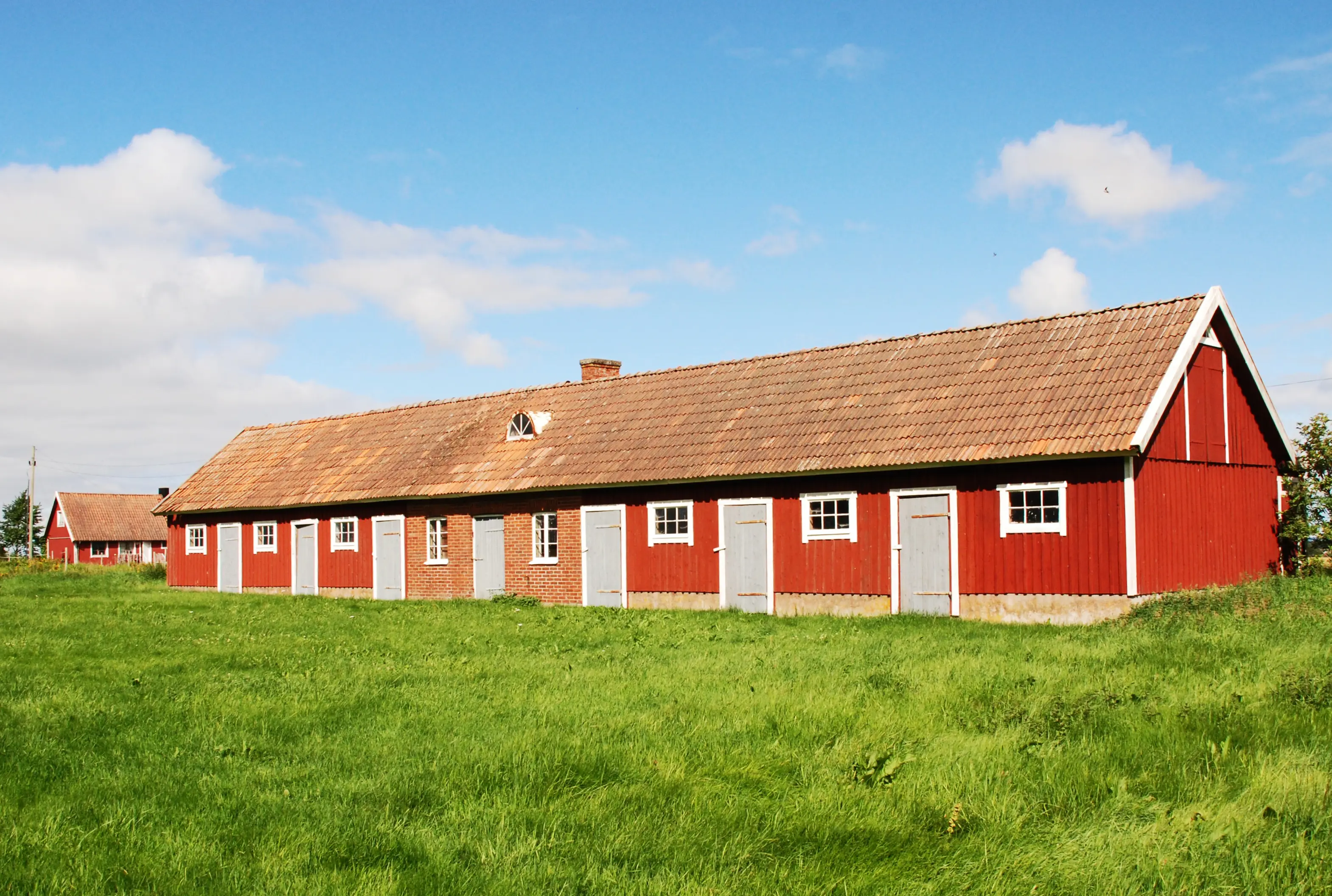 Tomarps kungsgård. Röda trähus, ekonomibyggnader för jordbruksverksamheten.