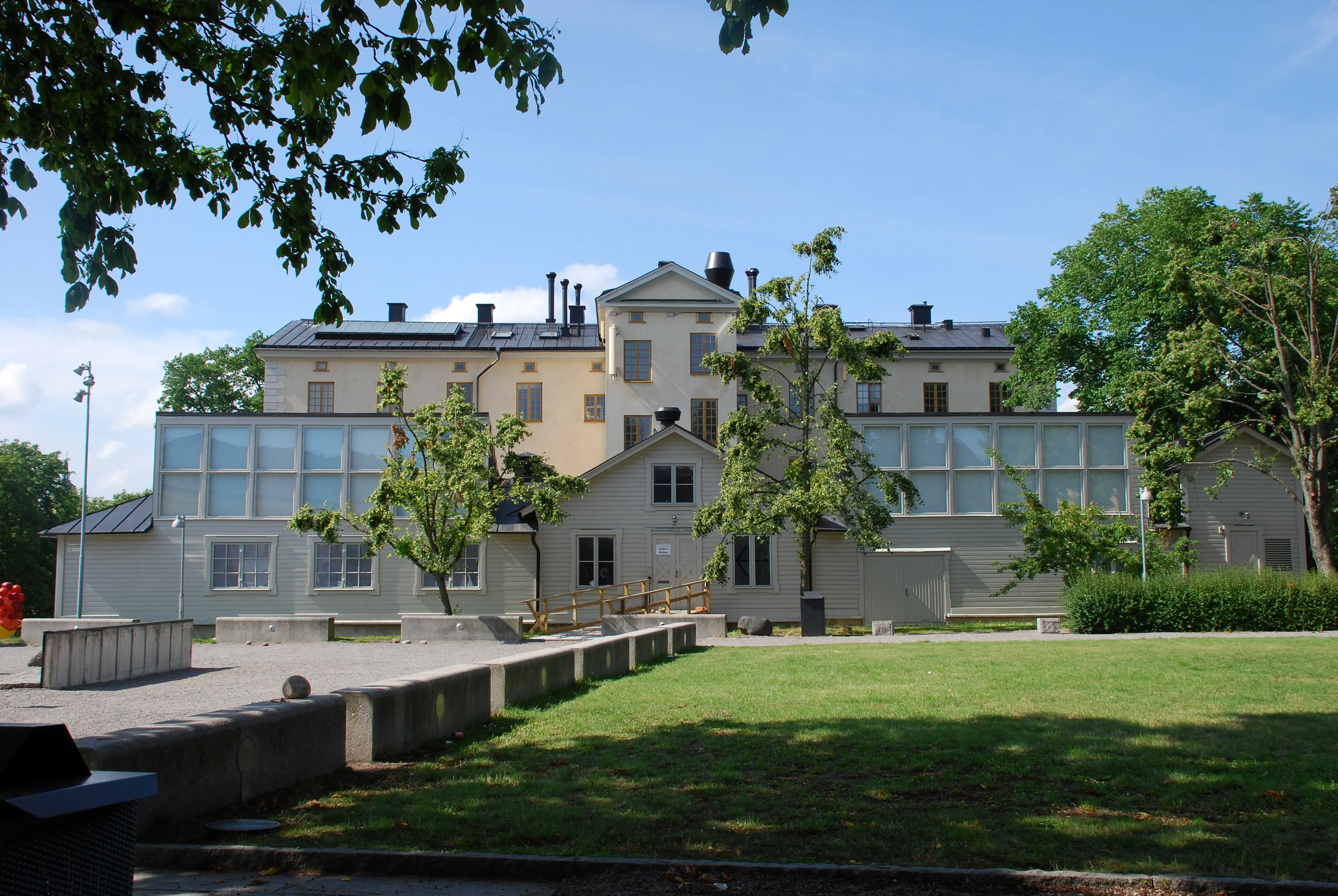 Ateljéhuset på Skeppsholmen. Vitputsad klassicistisk byggnad med moderna tillbyggnader.