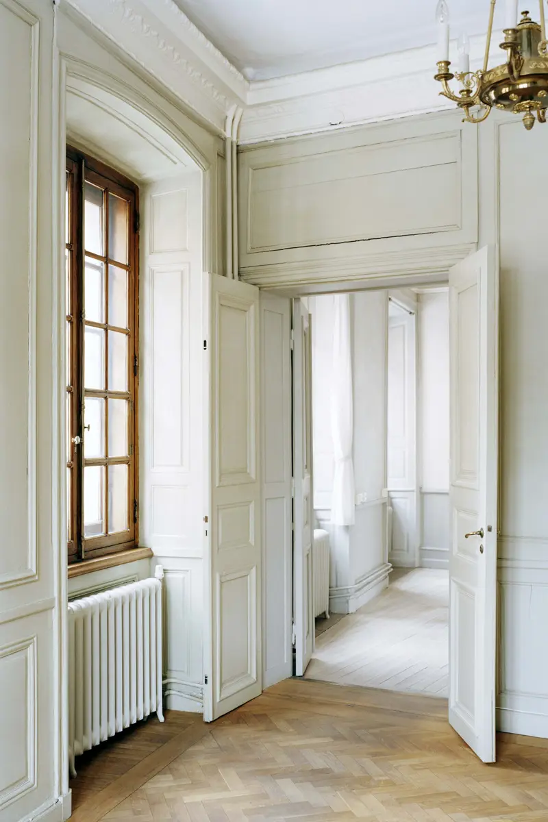 Oxenstiernska palatset. Rum med fönster i omålat trä. Dubbeldörrar är öppna till ett annat rum. Väggar och dörrar är vita.