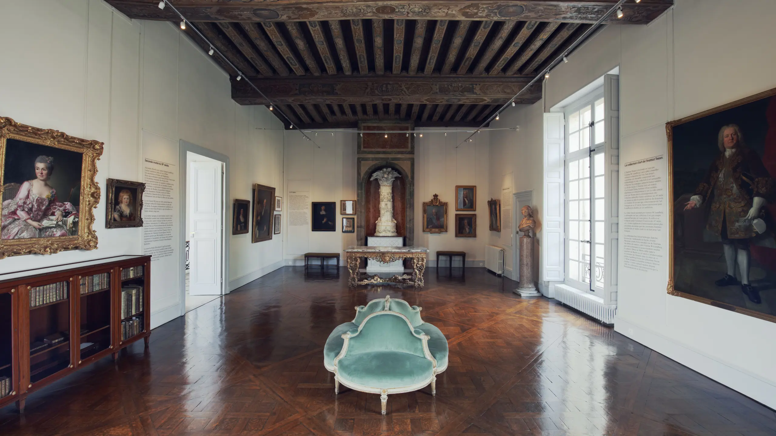 Svenska institutet i Paris. Utställningsrum med mönstrat trägolv och rejäla, målade takbjälkar. På väggarna hänger porträtt.