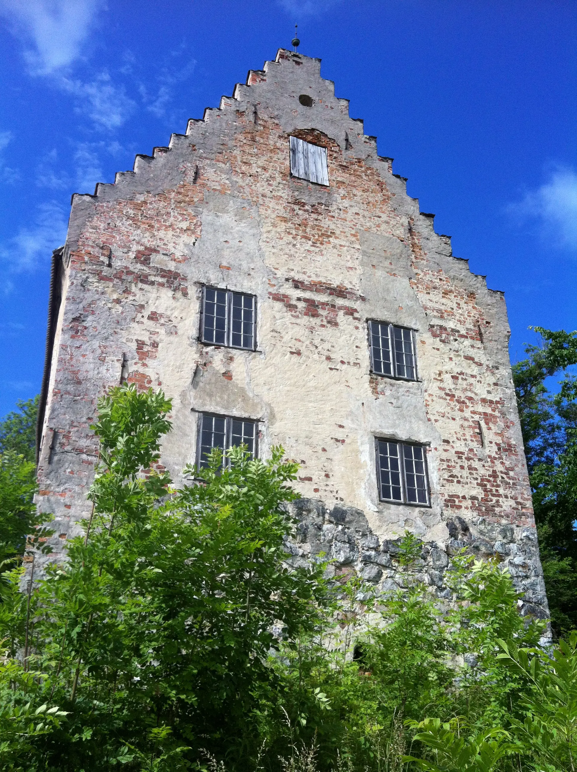 Utö hus, en borg-liknande tegelbyggnad med trappstens-gavel. Fasaden har ankarslut och avflagnad puts.