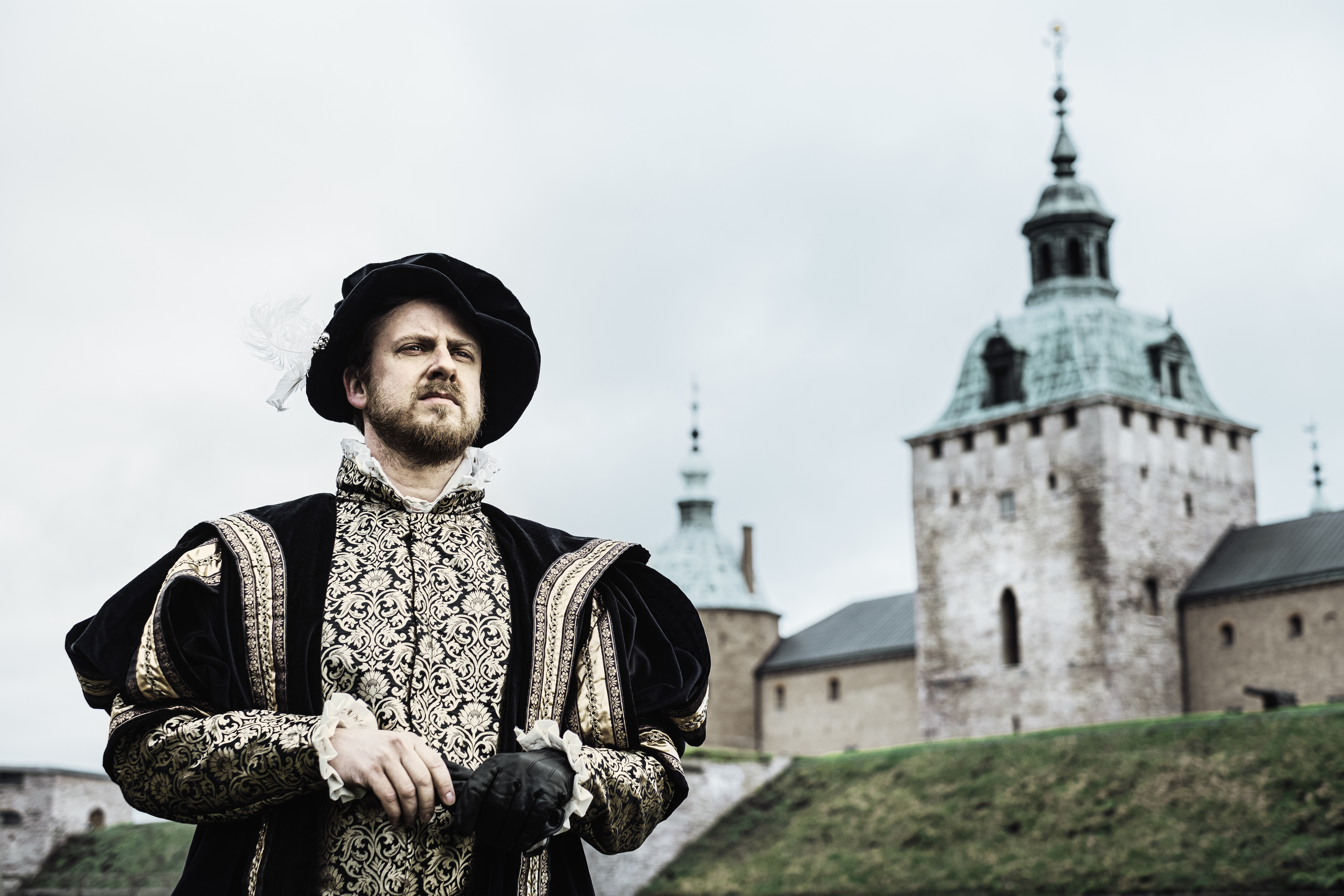 En person utklädd till Gustav Vasa står vid vallgraven med Kalmar slott i bakgrunden.