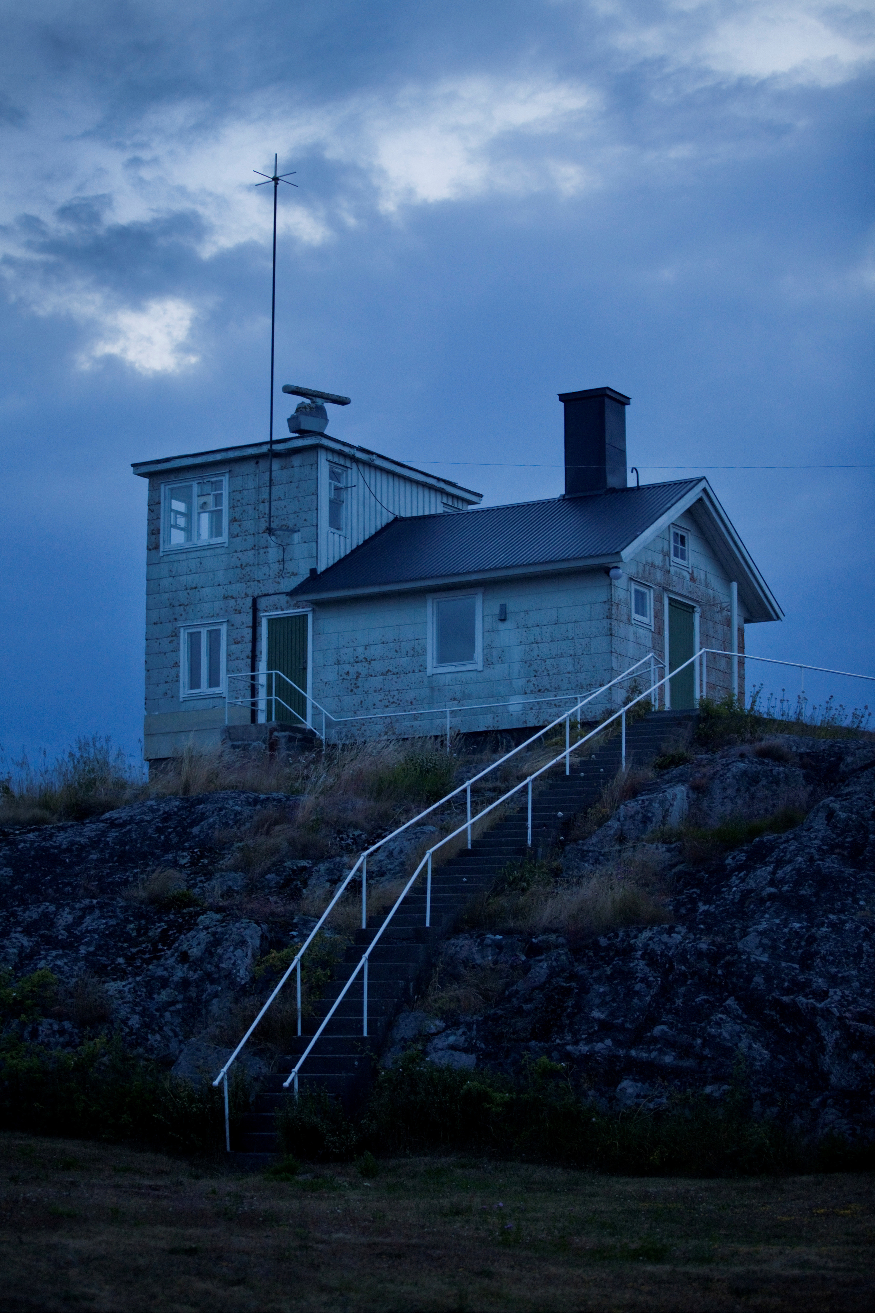 Lotsutkiken på Häradskär ligger på en hög klippa. En brant trappa leder upp till en vit liten stuga med ett lågt torn. På tornets tak sitter en radar.