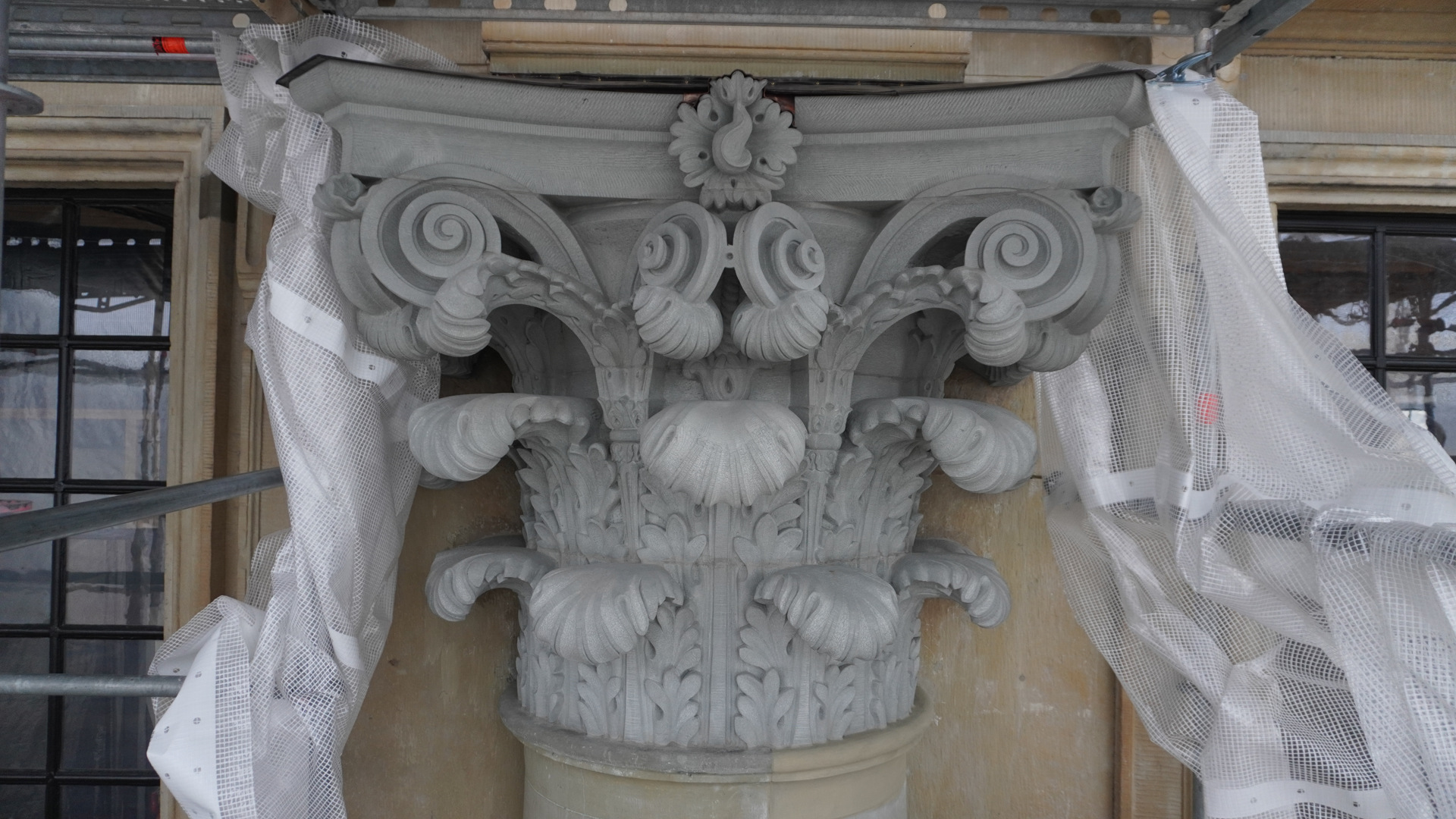 Stockholms slott. Stenkapitäl med växtornamentik, omgivet av byggställningar och skyddsplast.
