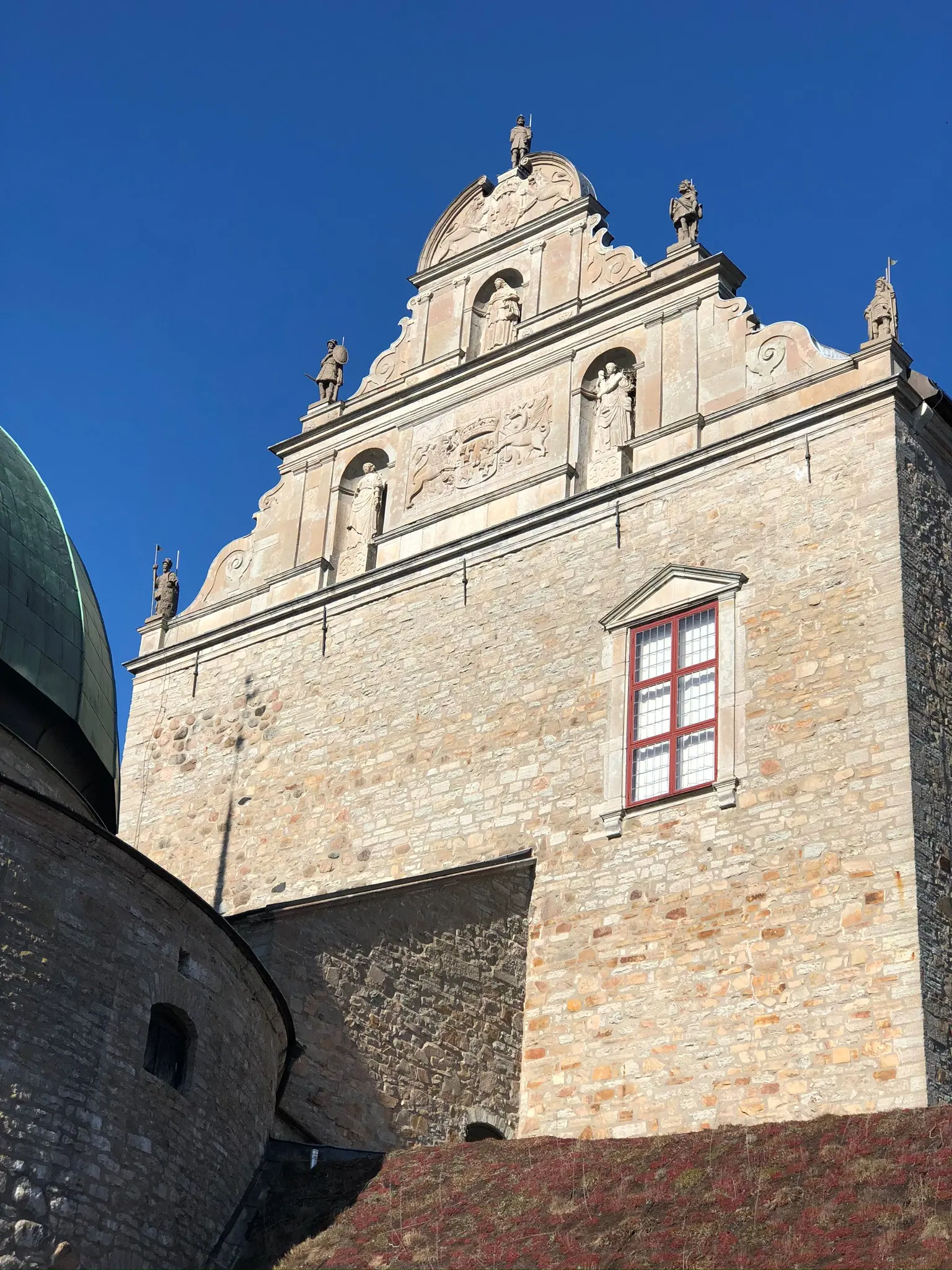 Praktgavel på Vadstena slott. Gaveln är smyckad med skulpturer, reliefer och en vapensköld.